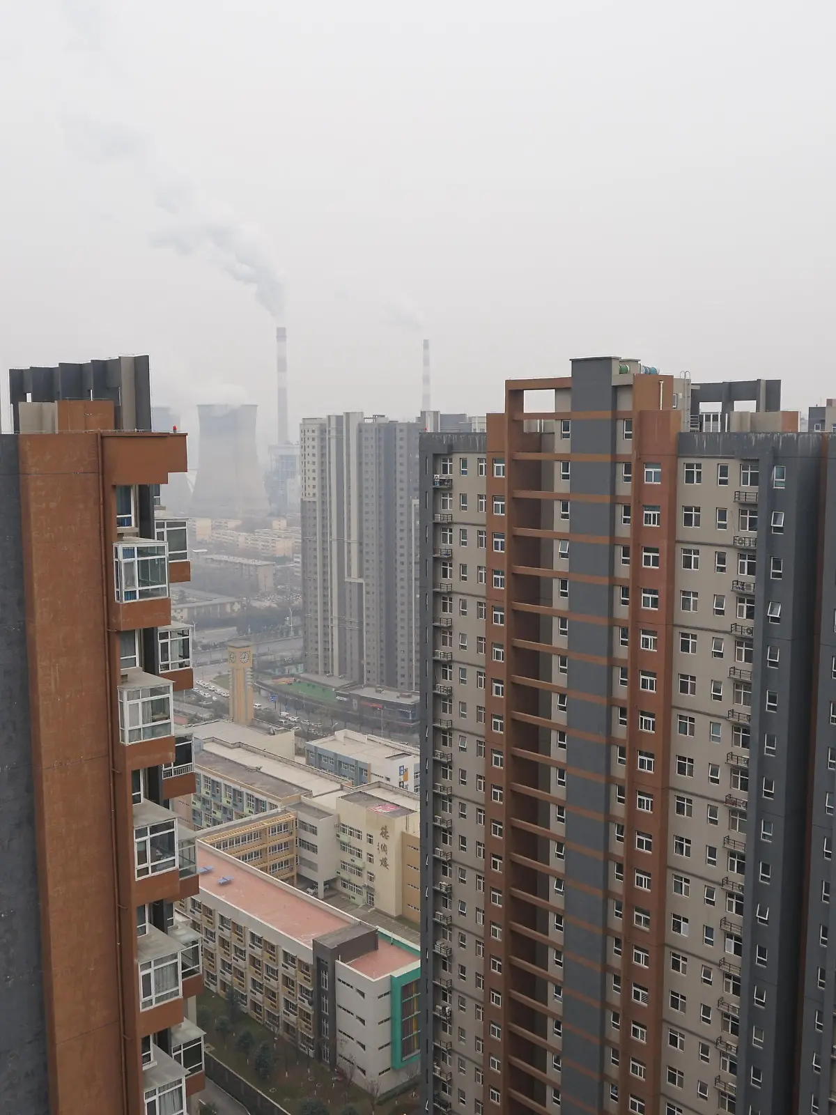 XI'AN, CHINA - DECEMBER 23, 2021 - A view of a coal-fired power plant and buildings in Xi 'an, Shaanxi Province, China, on December 23, 2021. Xi 'an has implemented city-wide closed management of units and communities.