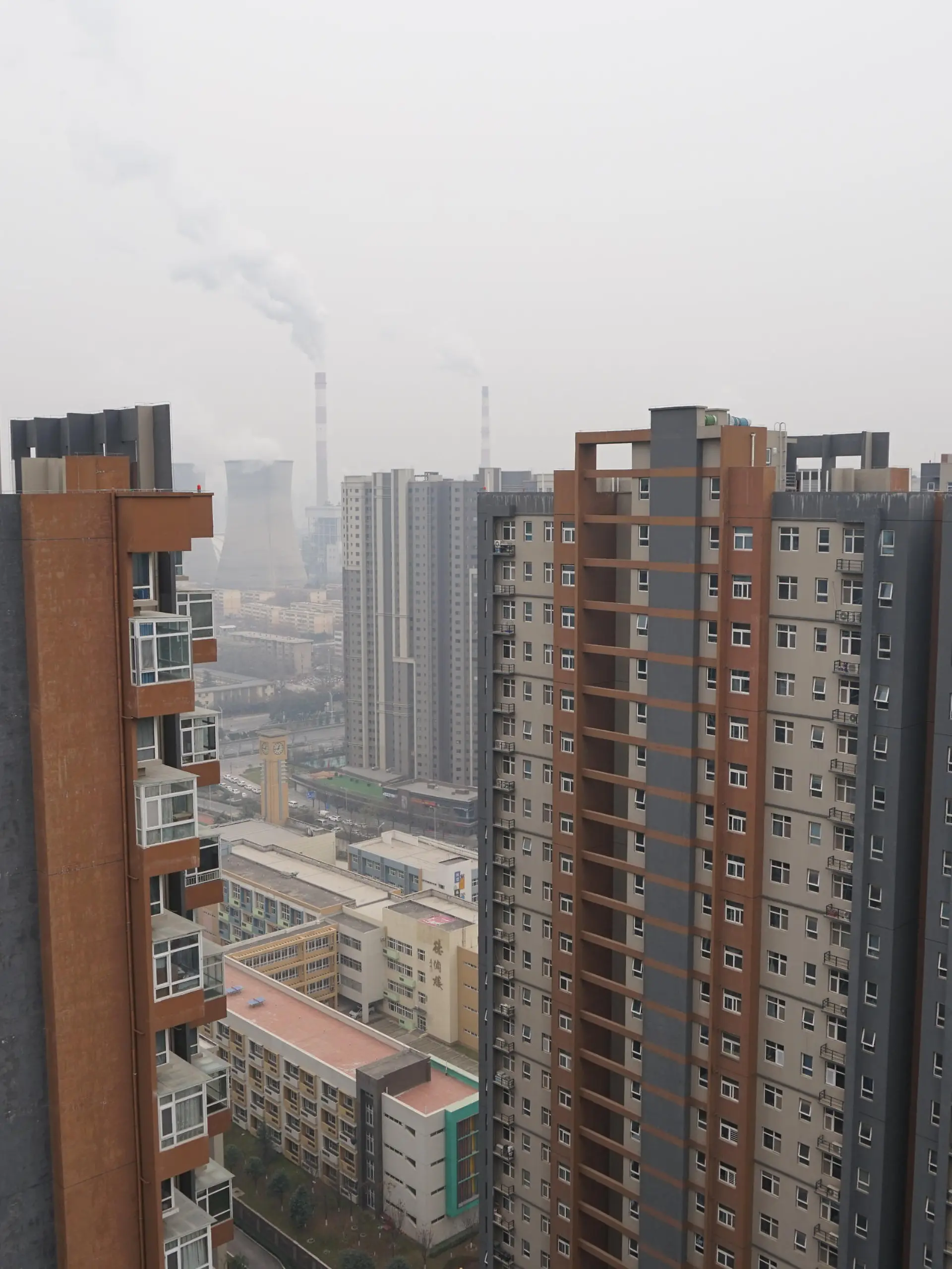 XI'AN, CHINA - DECEMBER 23, 2021 - A view of a coal-fired power plant and buildings in Xi 'an, Shaanxi Province, China, on December 23, 2021. Xi 'an has implemented city-wide closed management of units and communities.