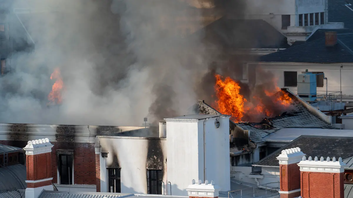 02.01.2022, Südafrika, Kapstadt: Flammen schlagen aus einem Gebäude des südafrikanischen Parlaments. Feuerwehrleute kämpften seit den frühen Morgenstunden gegen lodernde Flammen an der Rückseite des Gebäudekomplexes, der die Alte Versammlungskammer und den Nationalrat der Provinzen beherbergt. Foto: Jerome Delay/AP/dpa +++ dpa-Bildfunk +++