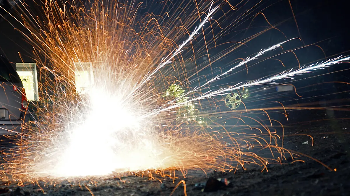 Die Gefahr eines explodierenden Knallkörpers. Feuerwerkskörper explodieren auf dem Boden und offenbaren die große Hitze und Brandgefahr. *** The danger of exploding firecrackers Firecrackers explode on the ground, revealing the great heat and fire danger