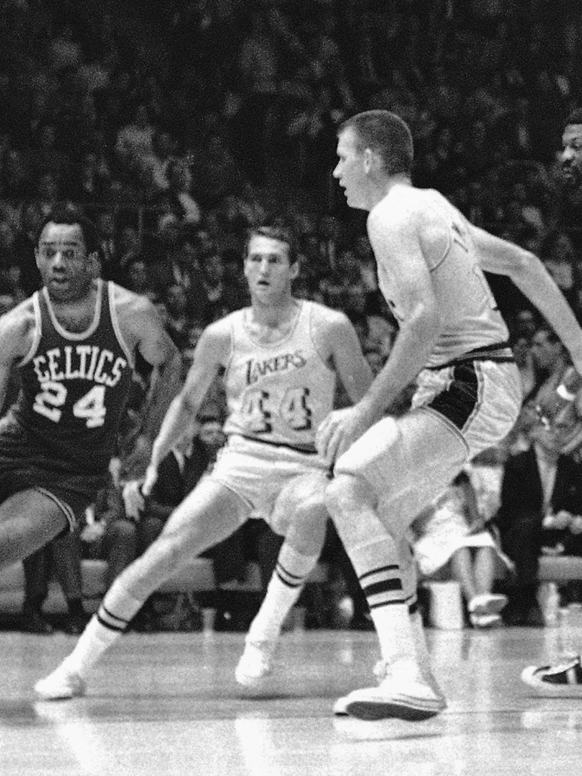 ARCHIV - 02.05.1968, USA, Los Angeles: Bostons Sam Jones (l) zieht an Jerry West (44) von den Lakers vorbei und läuft an der Grundlinie entlang zum Korb im NBA-Playoff-Spiel der beiden Teams. Rechts stehen Darrall Imhoff von den Lakers und Bill Russell von den Celtics. Die amerikanische Basketball-Legende Sam Jones ist tot. Das Mitglied der Ruhmeshalle sei im Alter von 88 Jahren am Donnerstagabend gestorben, teilte ein Sprecher seines früheren Teams Boston Celtics der Nachrichtenagentur AP und weiteren US-Medien am Freitag mit. Foto: Hf/AP/dpa +++ dpa-Bildfunk +++