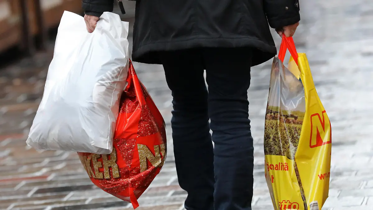 ARCHIV - 20.12.2018, Mecklenburg-Vorpommern, Rostock: Eine Frau geht mit Einkaufstüten aus Plastik über den Fußweg. Leichte Plastiktüten dürfen in Deutschland ab 2022 nicht mehr ausgegeben werden. Ab dem 1. Januar dürfen an den deutschen Ladenkassen keine Einkaufstüten aus Plastik mehr angeboten werden. Es geht um die Standard-Tüten. Foto: Bernd Wüstneck/dpa +++ dpa-Bildfunk +++