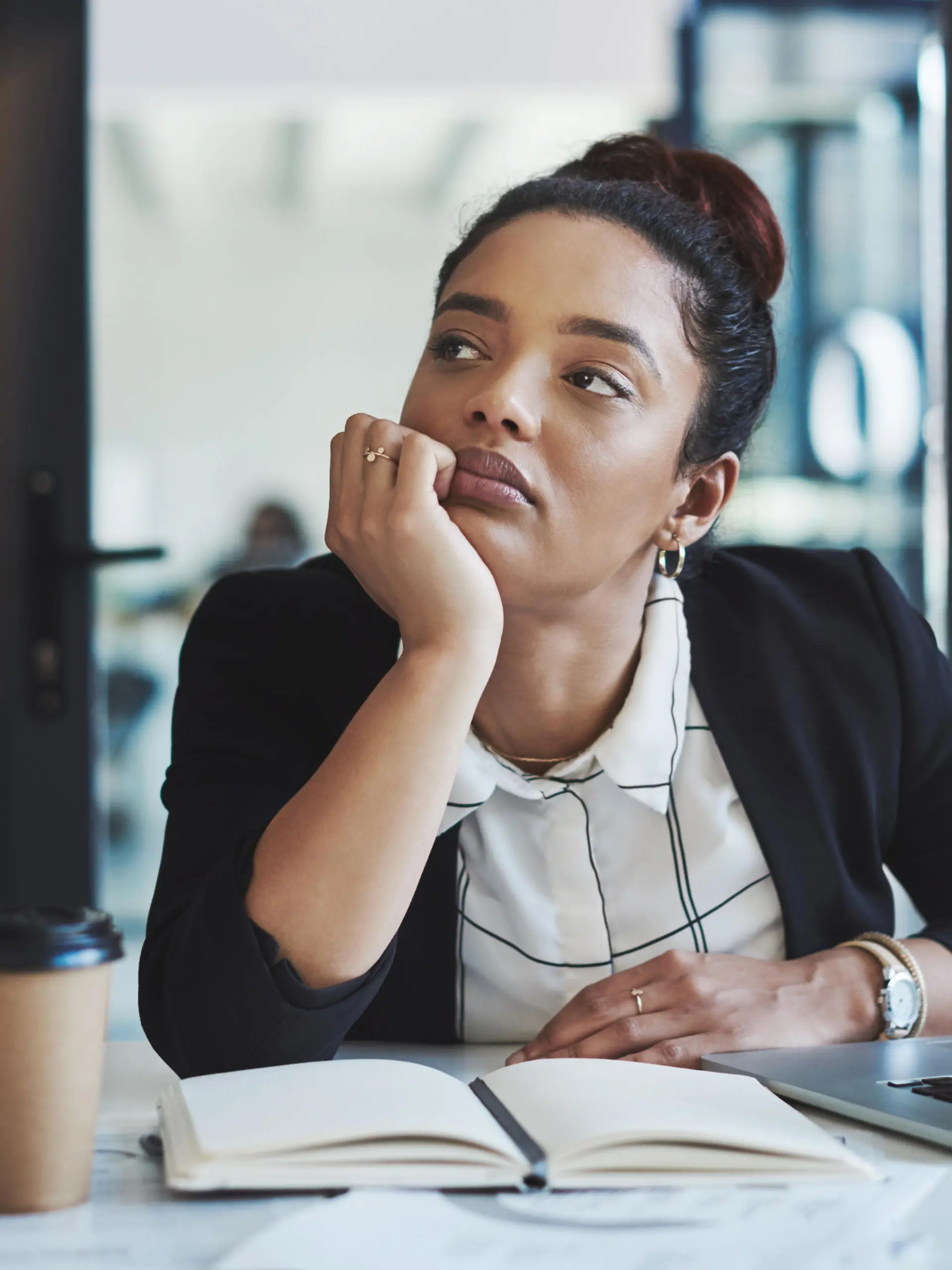 Shot of a young businesswoman looking bored while working at her desk in a modern office