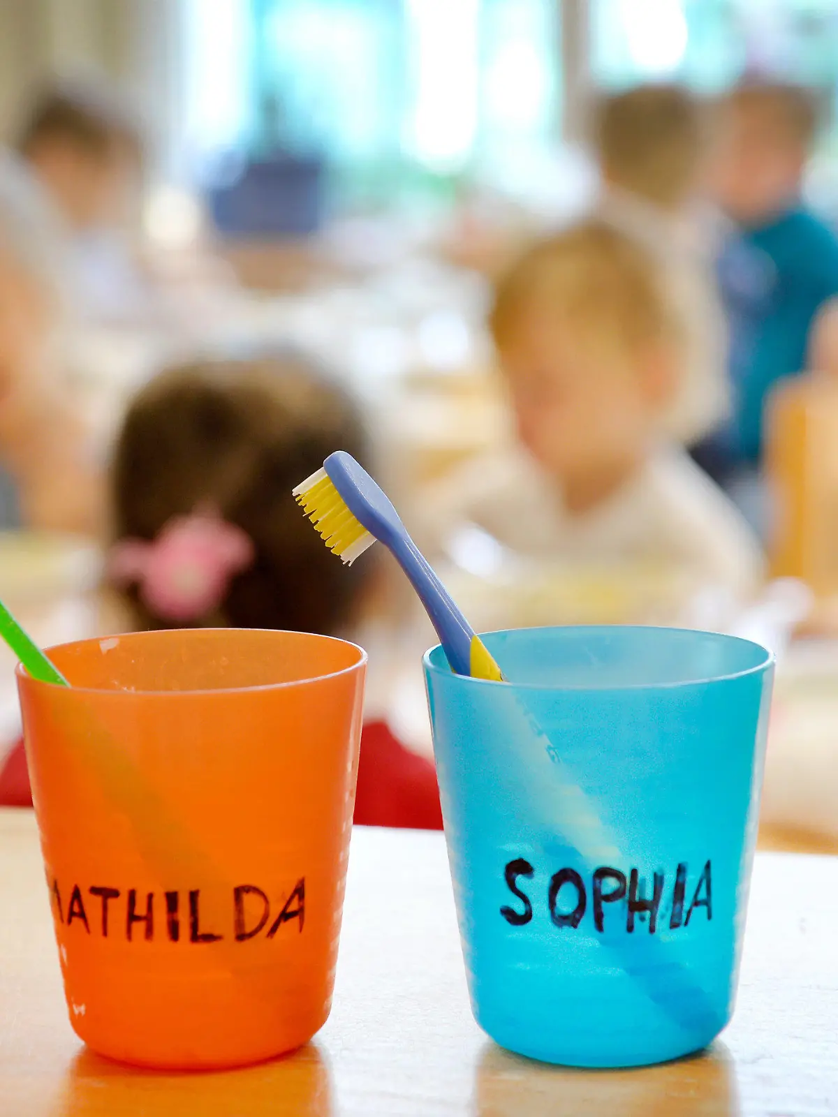 ARCHIV - 17.04.2016, Nordrhein-Westfalen, Düsseldorf: Zahnbürsten und Zahnputzbecher mit den Vornamen von Kinder stehen in einer Kindertagesstätte auf einem Tisch. Mia und Noah sind nach einer Rangliste des Hobby-Namensforschers Bielefeld die beliebtesten Vornamen in Baden-Württemberg. (zu dpa «Mia und Noah sind im Südwesten die beliebtesten Vornamen») Foto: Monika Skolimowska/dpa +++ dpa-Bildfunk +++