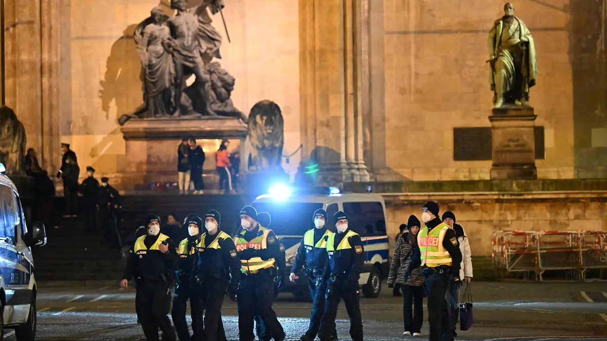 30.12.2021, Bayern, München: Einsatzkräfte der Polizei stehen auf dem Odeonsplatz vor der Feldherrnhalle, falls sich "Spaziergänger" versammeln sollten. Immer mehr bayerische Kommunen verbieten unangemeldete Versammlungen und «Spaziergänge» zum Protest gegen Corona-Maßnahmen oder verfügen strenge Auflagen. Foto: Peter Kneffel/dpa +++ dpa-Bildfunk +++