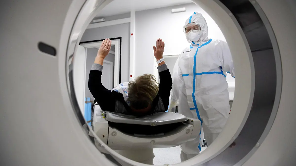 6699994 19.11.2021 Medical specialists wearing protective gear prepare a patient for a CT scan at a pavilion of the Exhibition of Achievements of National Economy (VDNH), which was converted into a reserve hospital for people suffering from the coronavirus disease, in Moscow, Russia. Ilya Pitalev / Sputnik