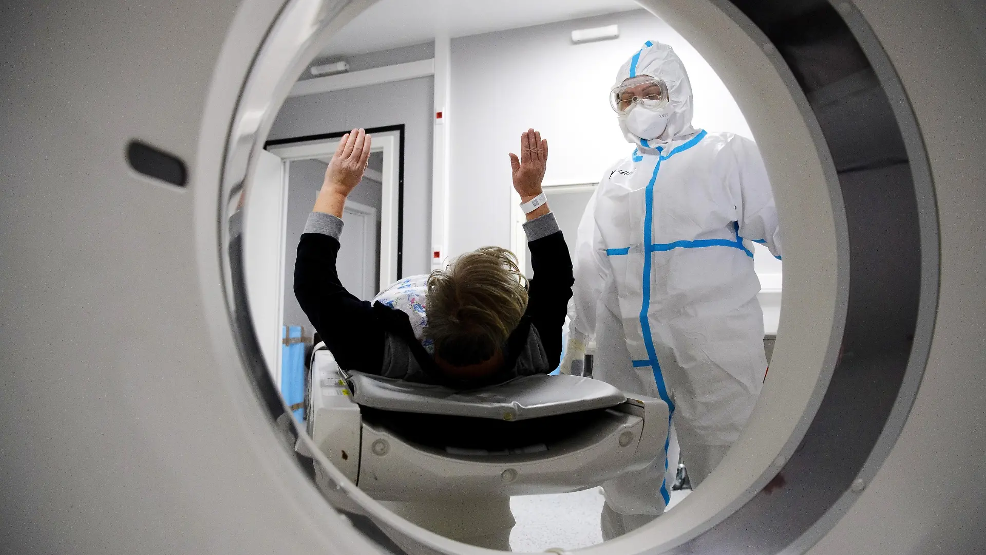 6699994 19.11.2021 Medical specialists wearing protective gear prepare a patient for a CT scan at a pavilion of the Exhibition of Achievements of National Economy (VDNH), which was converted into a reserve hospital for people suffering from the coronavirus disease, in Moscow, Russia. Ilya Pitalev / Sputnik