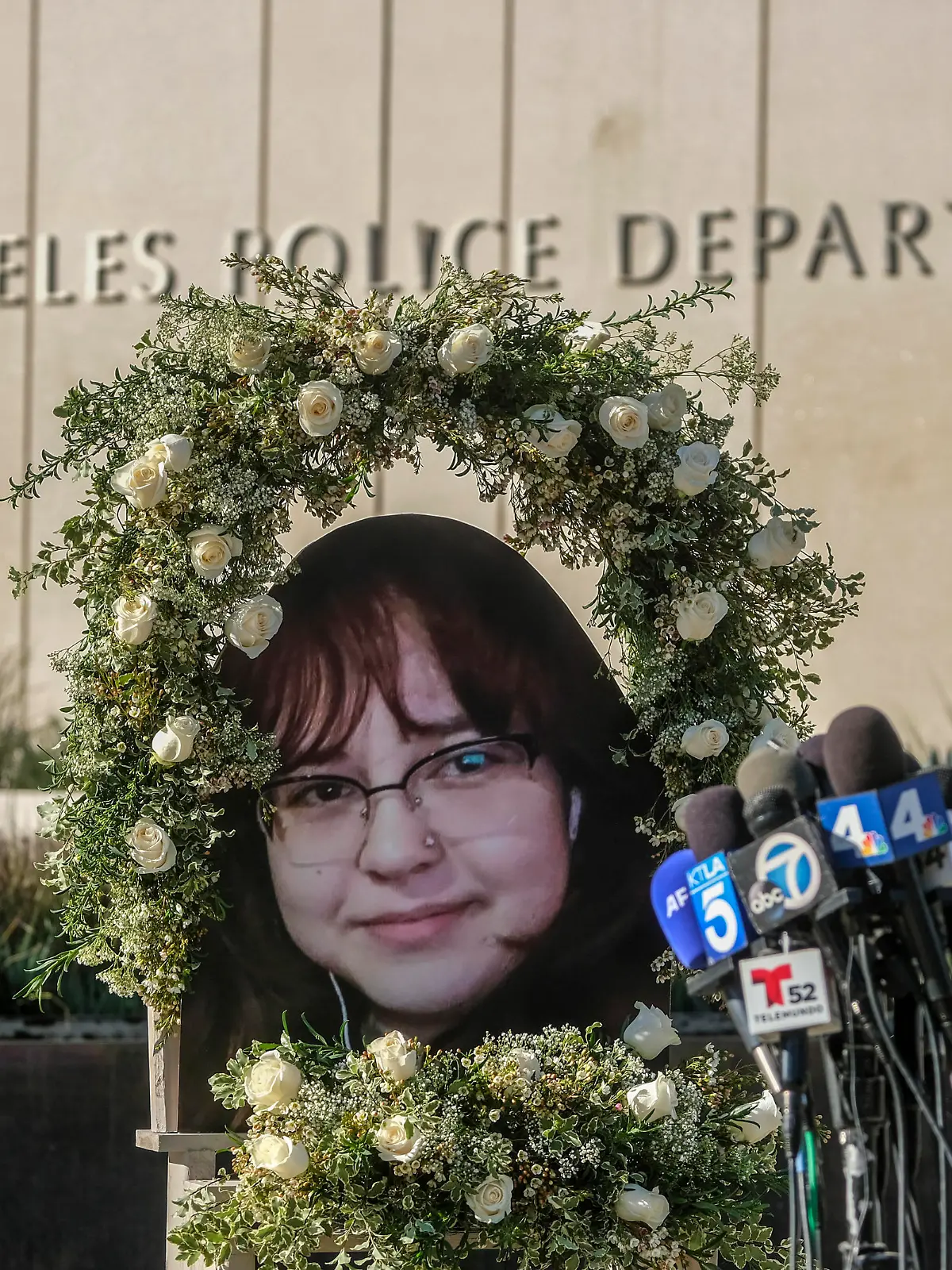A wreath with a picture of Valentina Orellana-Peralta, is displayed at a news conference outside Los Angeles Police Department Headquaters in Los Angeles, Tuesday, Dec. 28, 2021. The parents of Valentina Orellana-Peralta -- the 14-year-old girl killed by a stray bullet fired by an LAPD officer at a North Hollywood clothing store last week, and their attorneys held a news conference to discuss the family's demand for transparency from the Los Angeles Police Department. (AP Photo/Ringo H.W. Chiu)
