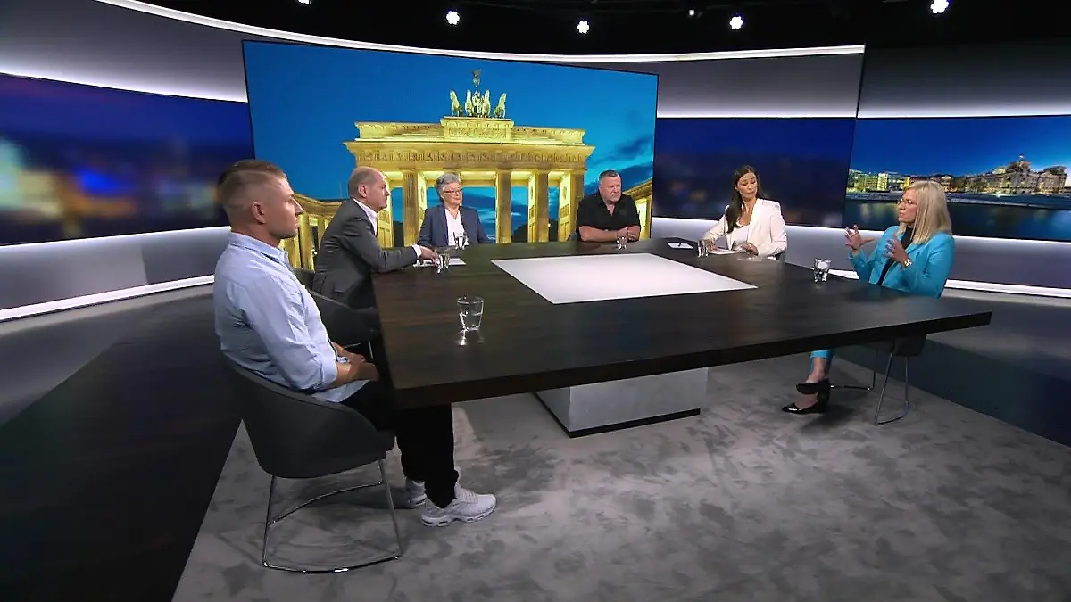 Vier Bürgerinnen und Bürger zusammen mit Bundeskanzler Olaf Scholz (SPD) und der RTL-Direkt-Moderatorin Pinar Atalay
