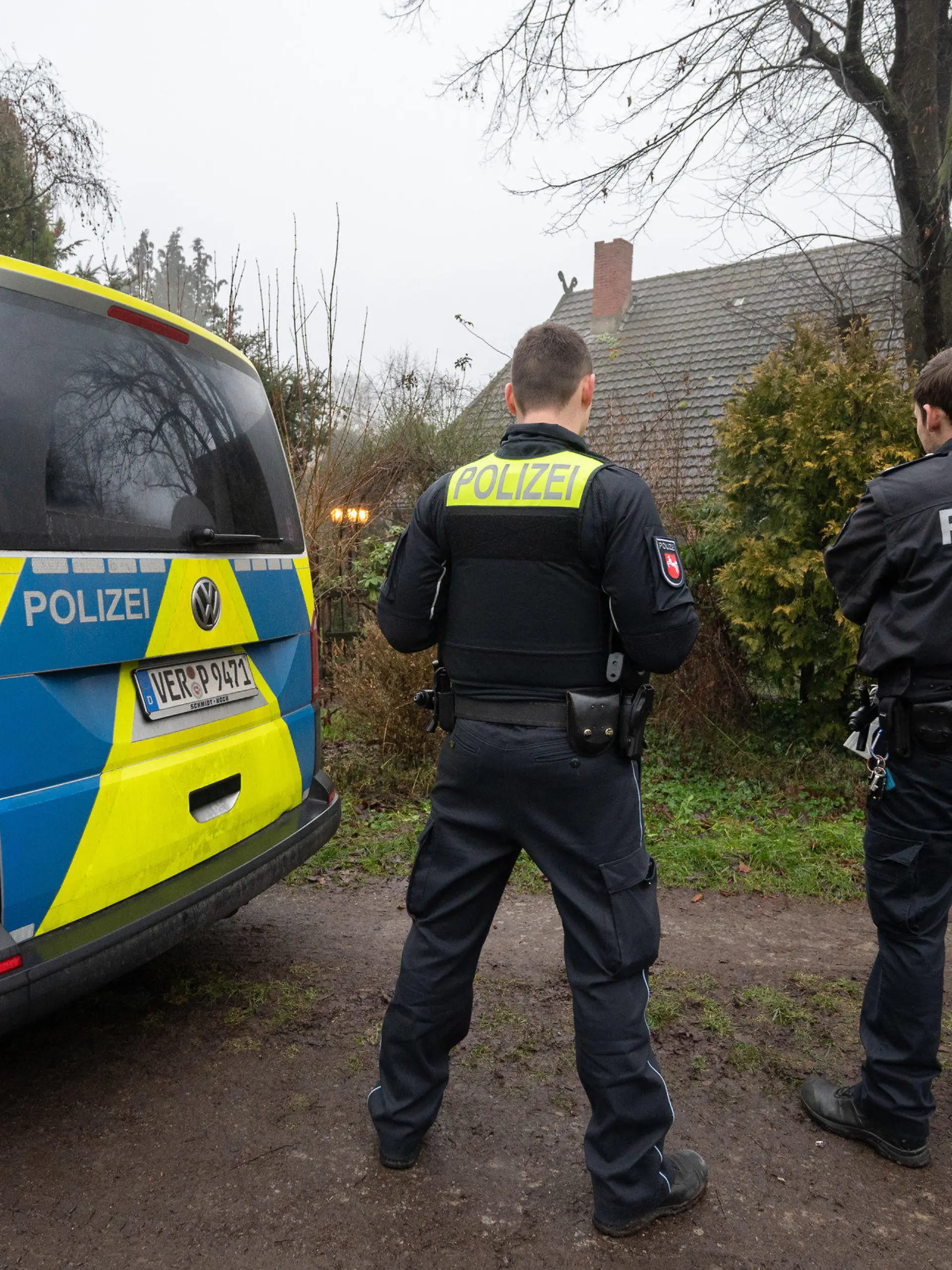 29.12.2021, Niedersachsen, Fischerhude: Polizisten stehen vor einem Haus, in dem am Vorabend zwei Tote aufgefunden wurden. Die Polizei ermittelt nach dem Fund der Leichen in Fischerhude nahe Bremen weiter zu den Hintergründen. Foto: Julian Stratenschulte/dpa +++ dpa-Bildfunk +++