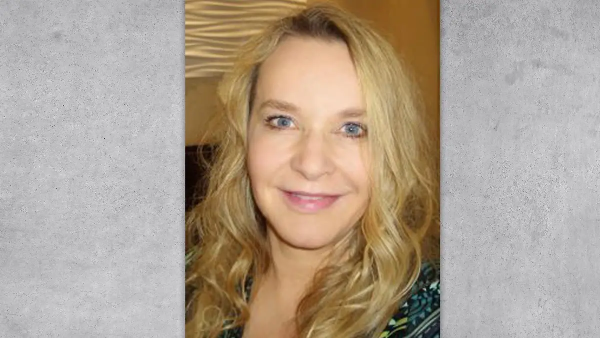 Eine blonde Frau lächelt in die Kamera.