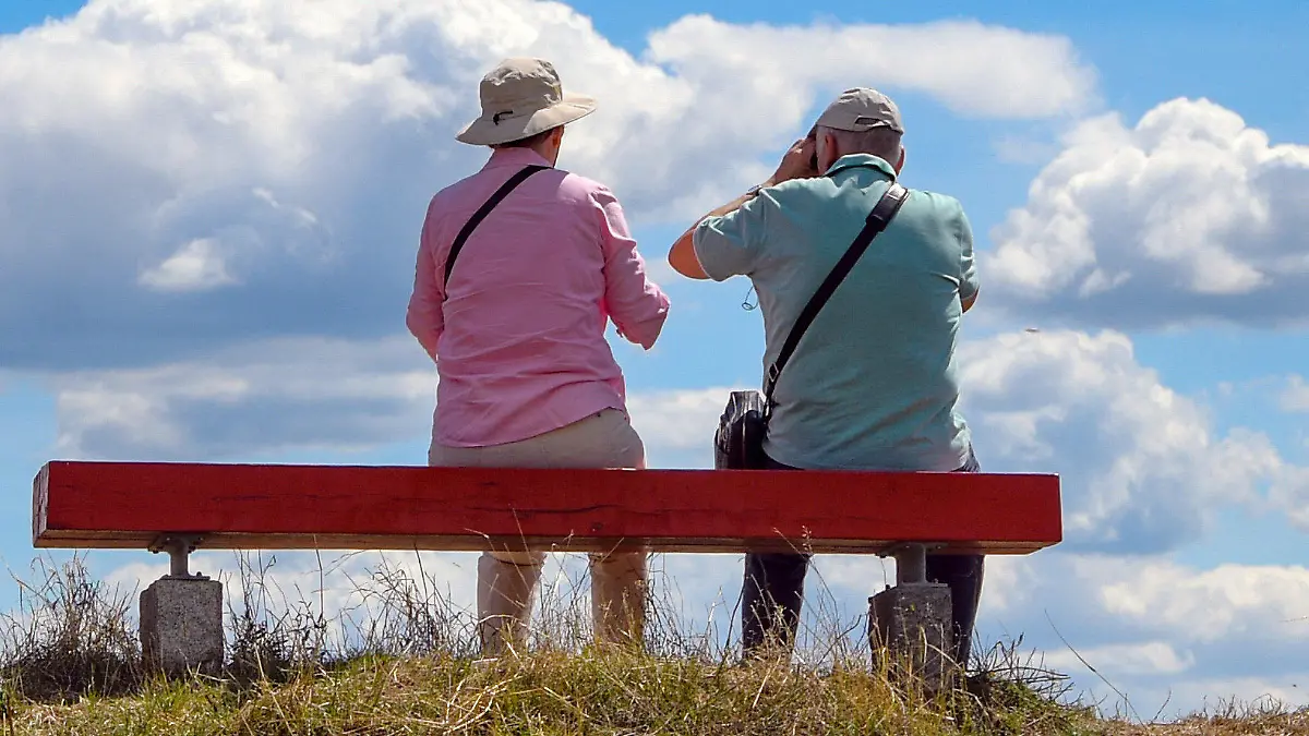 ARCHIV - 23.07.2020, Brandenburg, Stolpe: Zwei ältere Personen sitzen auf einer Bank die auf einem Hügel im Nationalpark Unteres Odertal steht. Die Menschen in Deutschland gehen im Schnitt immer später in Rente. So stieg das Zugangsalter zu Altersrenten bei Männern im vergangenen Jahr auf 64,4 Jahre, wie aus dem am Dienstag in Berlin veröffentlichten Rentenatlas der Deutschen Rentenversicherung hervorgeht. Foto: Patrick Pleul/dpa-Zentralbild/ZB +++ dpa-Bildfunk +++
