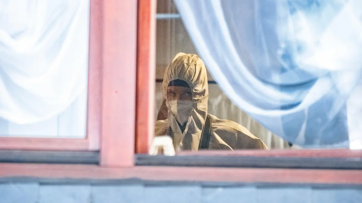 27.12.2021, Schleswig-Holstein, Glinde: Eine Beamtin der Spurensicherung arbeitet in einem Zimmer des Hauses. In dem Wohnhaus in Glinde bei Hamburg sind drei Tote gefunden worden. Es handelt sich um Kinder im Alter von 11 und 13 Jahren sowie einen Mann, alle mit Schussverletzungen, wie Polizei und Staatsanwaltschaft am Montagvormittag mitteilten. Foto: Markus Scholz/dpa - ACHTUNG: Person(en) wurde(n) aus rechtlichen Gründen gepixelt +++ dpa-Bildfunk +++