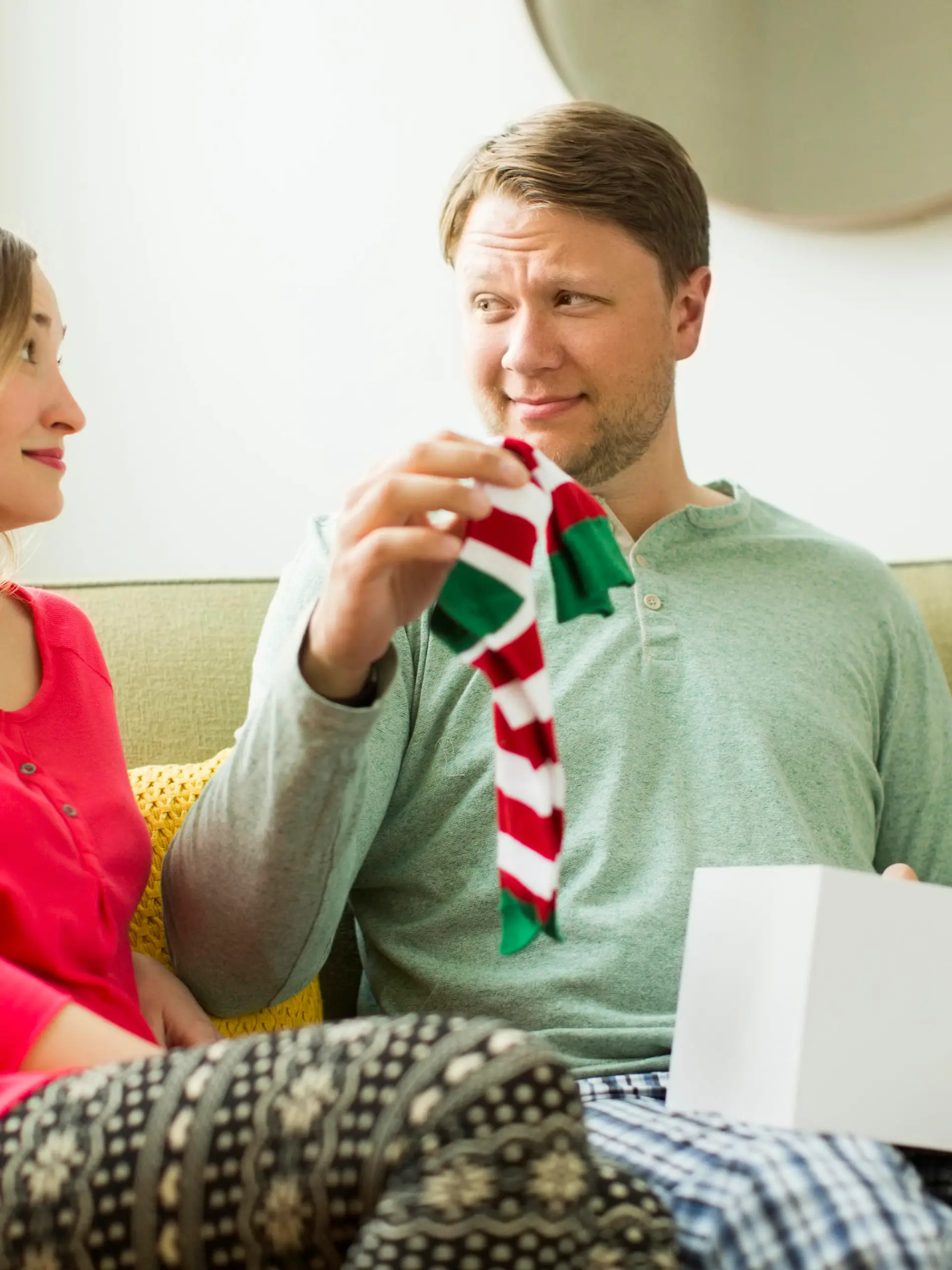 Ein Mann bekommt Socken von seiner Partnerin geschenkt.