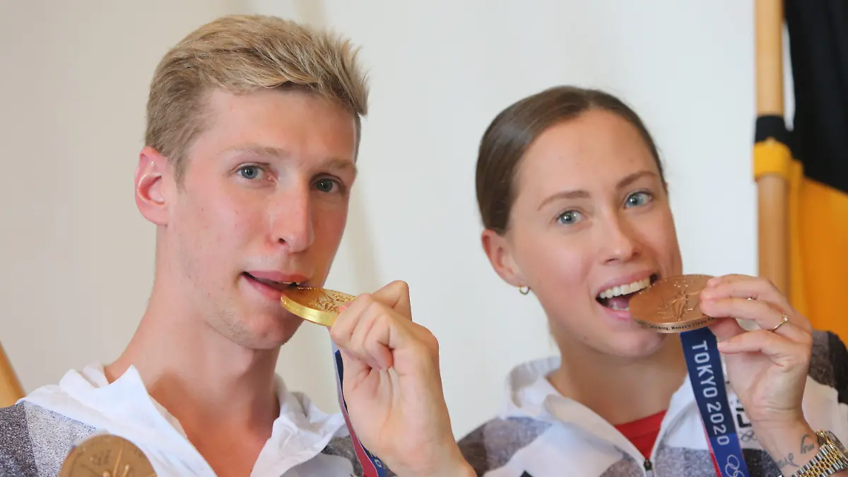 ARCHIV - 17.08.2021, Sachsen-Anhalt, Magdeburg: Florian Wellbrock, Olympiasieger im 10 Kilometer im Freiwasser, und Sarah Köhler, Bronze-Gewinnerin im 1500 Meter Freistil, zeigen ihre Medaillen. Schwimm-Olympiasieger Florian Wellbrock und Schwimmerin Sarah Köhler haben geheiratet. Die beiden Freistilschwimmer und Langstreckenexperten posteten am Dienstag bei Instagram Bilder von ihrer Trauung und versahen den Beitrag mit den Worten «Mr. & Mrs. Wellbrock» sowie dem Hashtag «justmarried». (zu dpa «Schwimm-Olympiasieger Wellbrock und Schwimmerin Köhler verheiratet») Foto: Matthias Bein/dpa-Zentralbild/dpa +++ dpa-Bildfunk +++