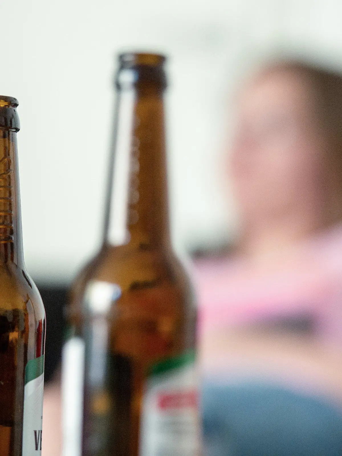 SYMBOLBILD - 28.05.2016, Berlin: Eine junge Frau sitzt hinter leeren Bierflaschen. Die Corona-Pandemie erhöht Experten zufolge das Risiko für Alkohol- und Drogenmissbrauch sowie das Zocken im Online-Casino. (zu dpa: «Suchthilfe zum Internationalen Tag gegen Drogenmissbrauch") Foto: Alexander Heinl/dpa +++ dpa-Bildfunk +++