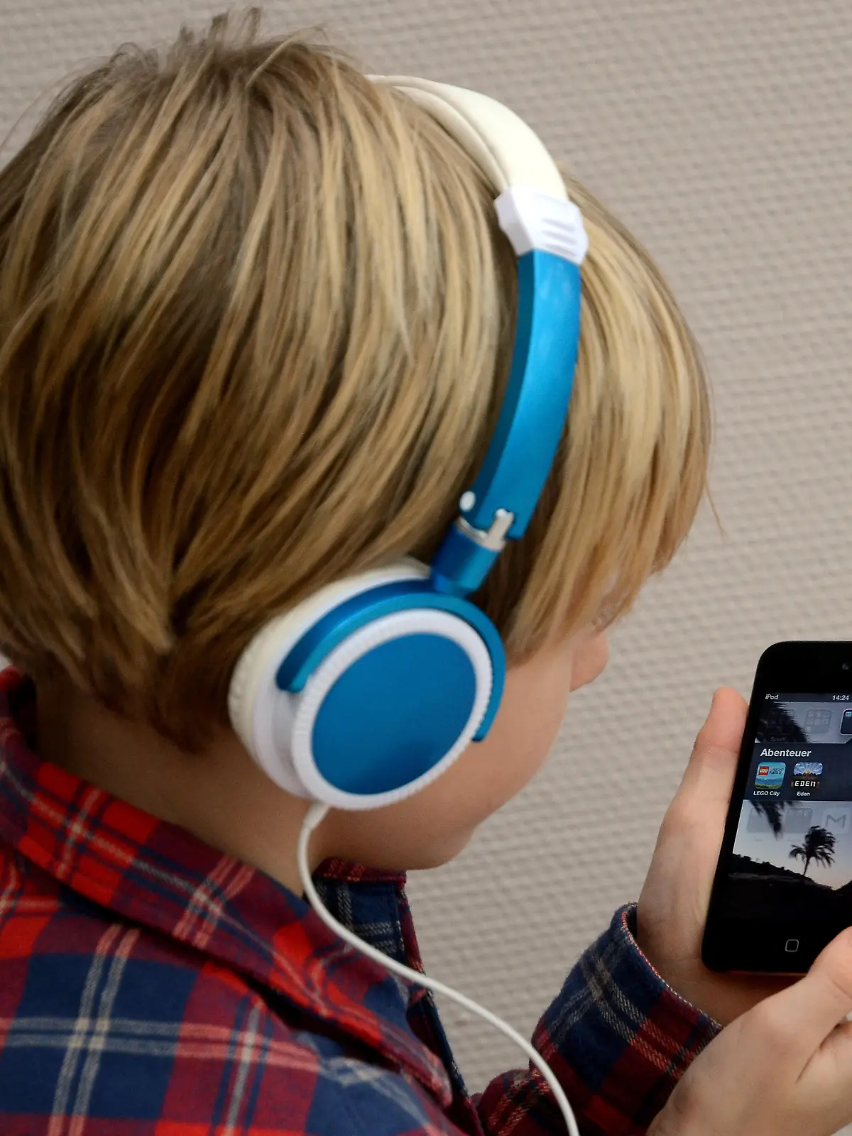 Ein Kind hört Musik mit seinem iPod von Apple (Foto vom 07.02.2014). Foto: Horst Ossinger/dpa