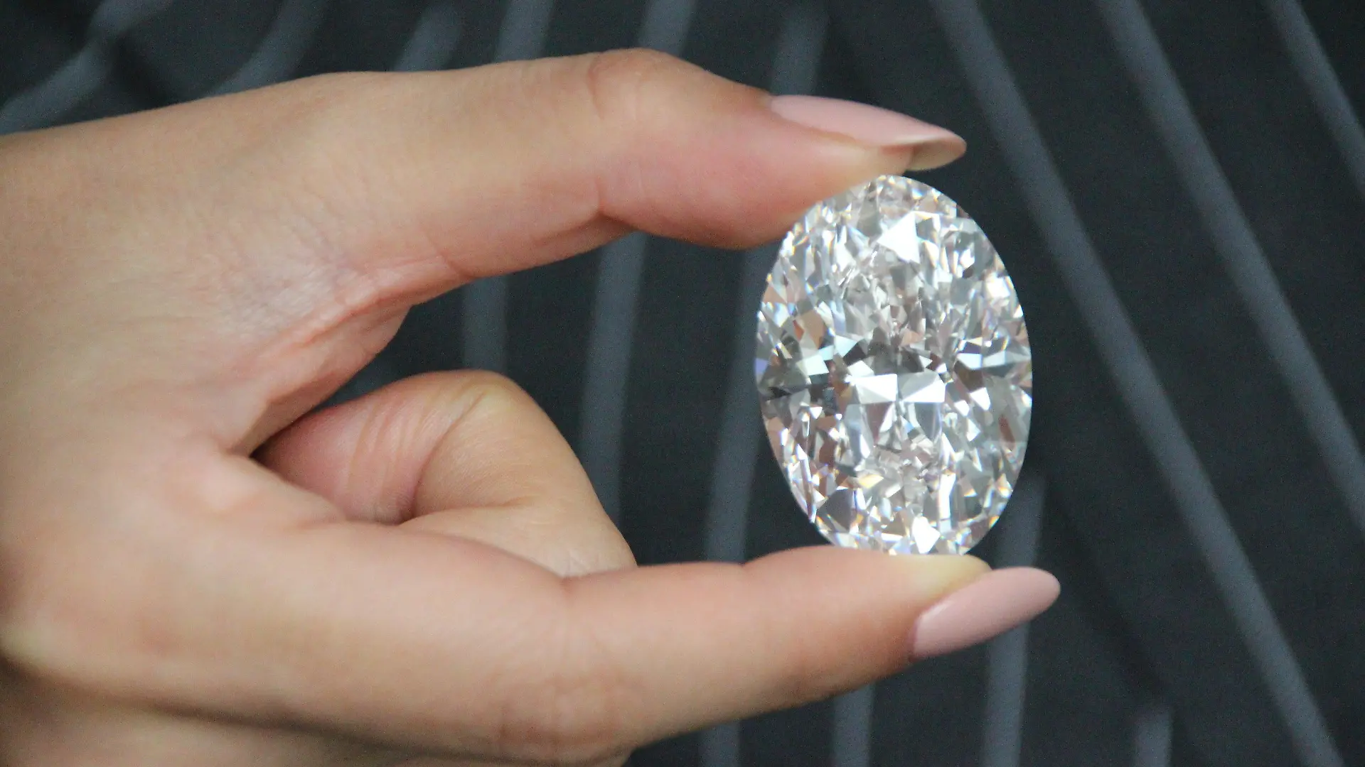 09.09.2020, USA, New York: Ein Model zeigt bei Sotheby's in New York einen großen, weißen Diamanten. Der in Kanada entdeckte wertvolle Edelstein soll im Oktober in Hongkong versteigert werden. Der weiße ovale Diamant mit 102,39 Karat sei erst der achte seiner Art, der weltweit versteigert werde, teilte das Auktionshaus Sotheby's am Donnerstag in New York mit. Foto: Christina Horsten/dpa +++ dpa-Bildfunk +++