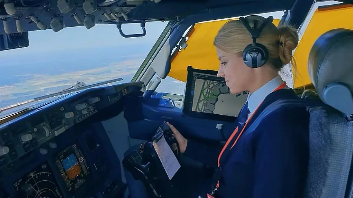 Eine junge Blondine sitzt am Steuer eines Flugzeugs.