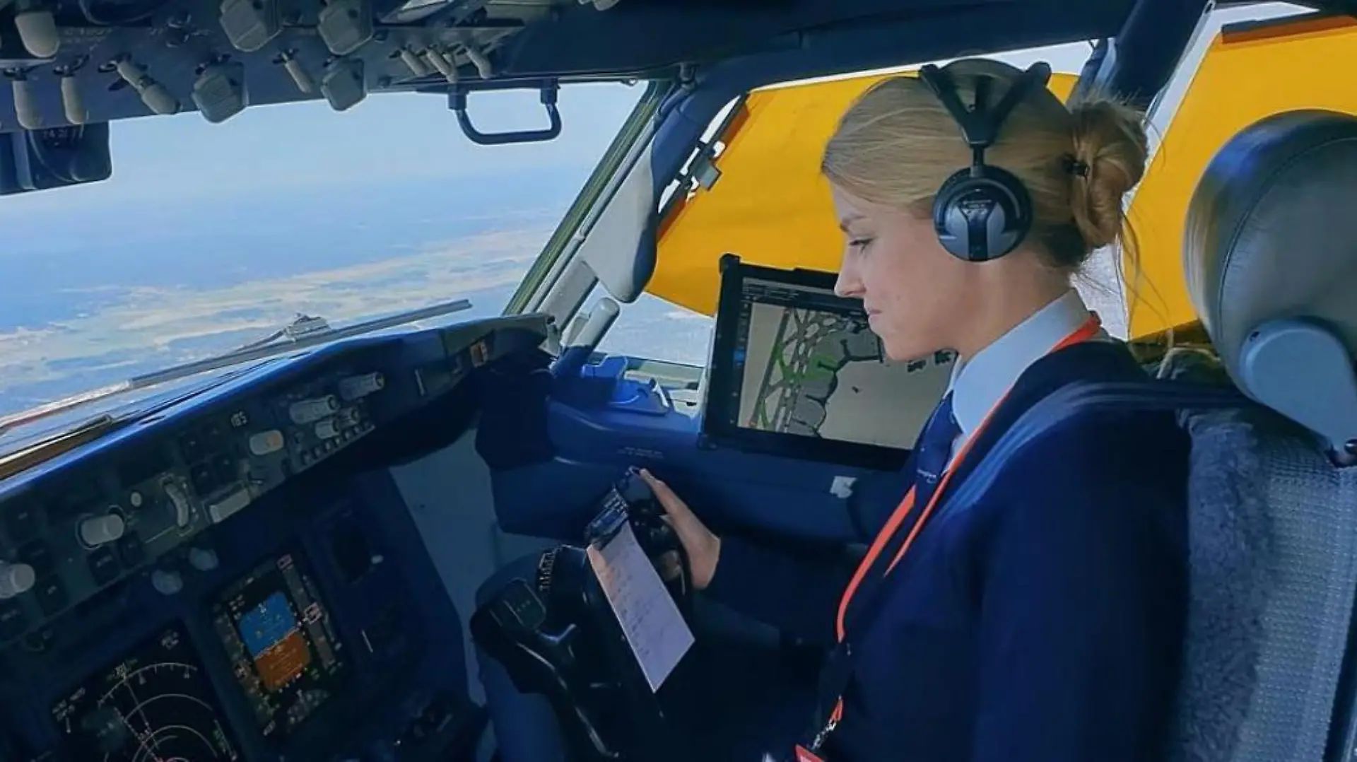 Eine junge Blondine sitzt am Steuer eines Flugzeugs.
