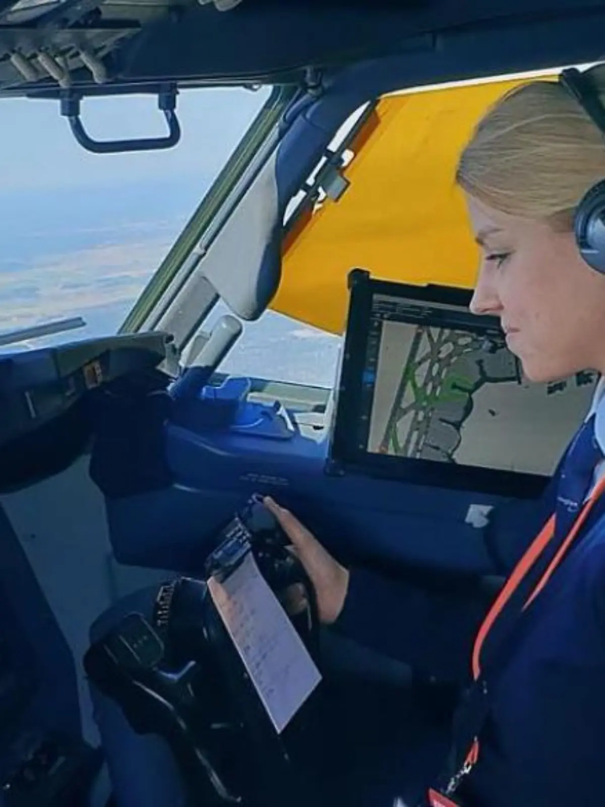 Eine junge Blondine sitzt am Steuer eines Flugzeugs.