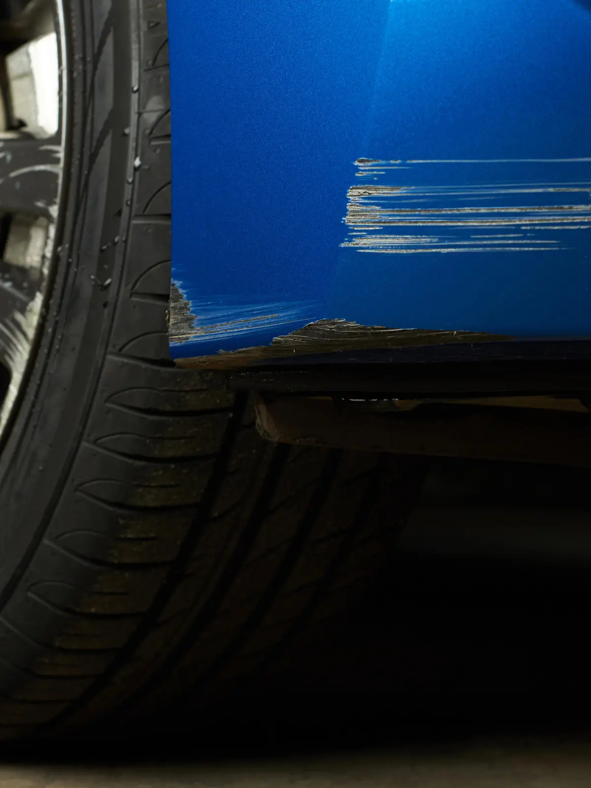 Finger zeigt auf Kratzer am Auto