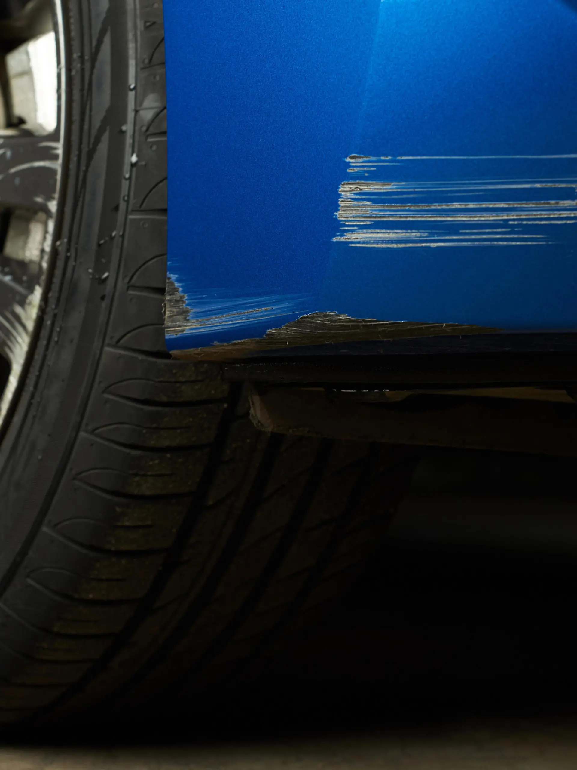Finger zeigt auf Kratzer am Auto
