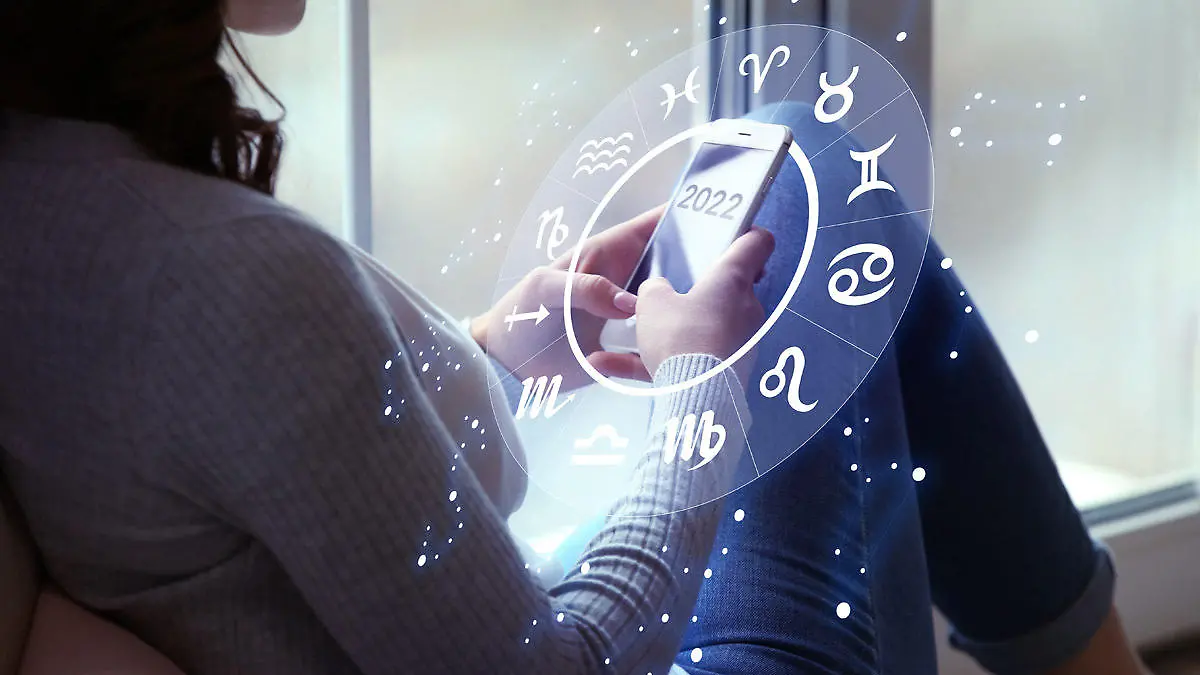 Frau checkt Horoskop an ihrem Handy
