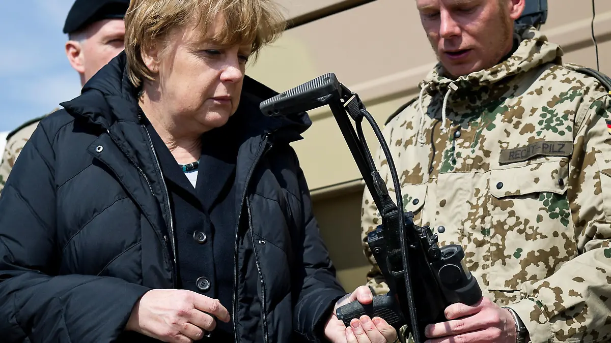 Bundeskanzlerin Angela Merkel informiert sich am Montag (12.03.2012) im Camp Marmal in Masar-i-Scharif bei einer Fernmeldeeinheit über deren Fähigkeiten, Geräte und Ausrüstung, hier prüft sie das Gewicht einer Maschinenpistole vom Typ MP 7. Merkel besucht die deutschen Truppen in Afghanistan. Foto: Bundesregierung/Steffen Kugler dpa +++(c) dpa - Bildfunk+++