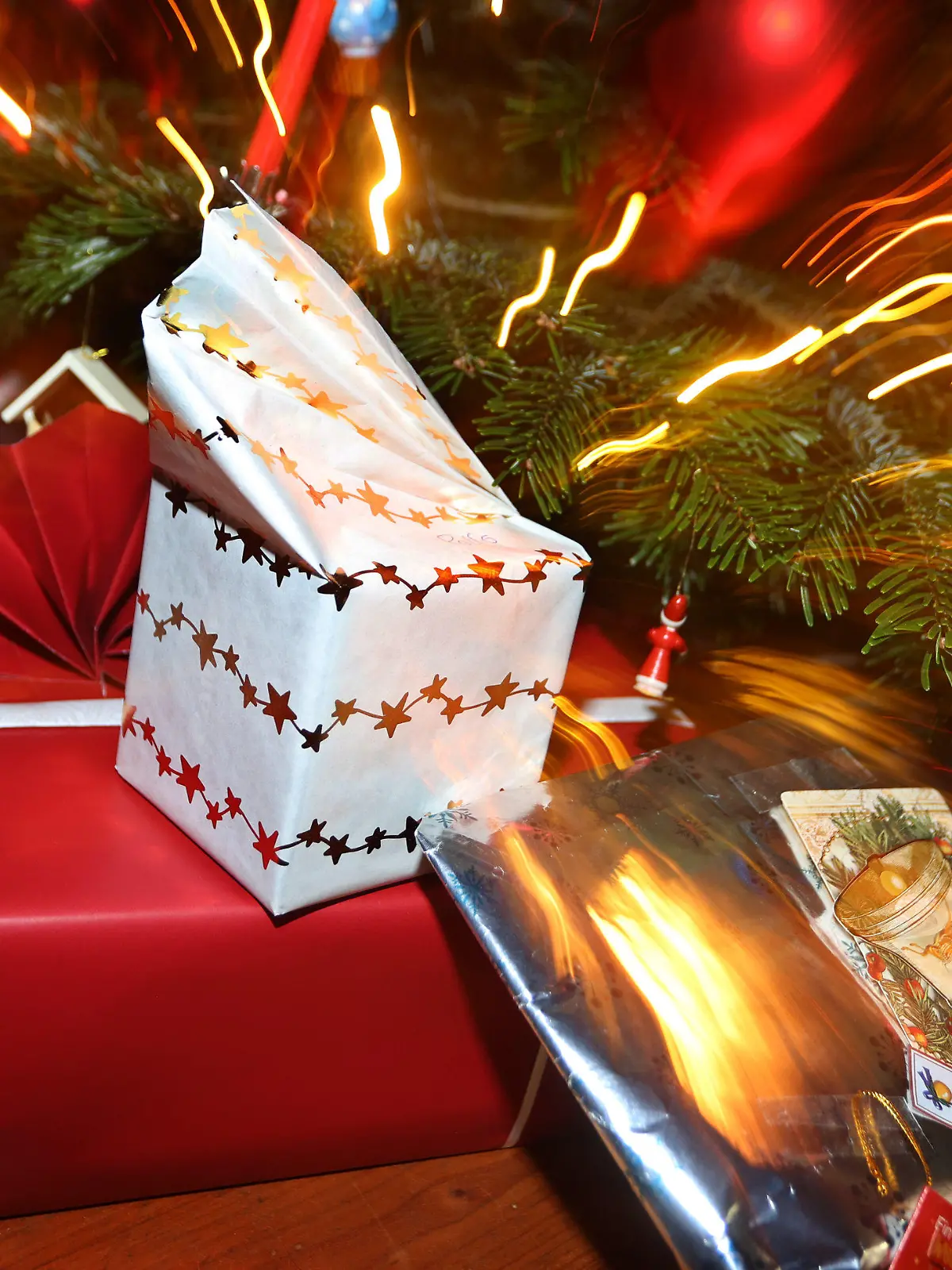 24.12.2021, Bayern, Kaufbeuren: Verpackte Geschenke liegen in einem Wohnzimmer unter einem festlich geschmücktem Weihnachtsbaum. Foto: Karl-Josef Hildenbrand/dpa +++ dpa-Bildfunk +++