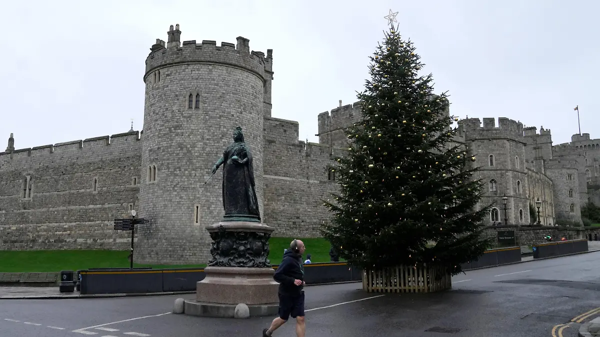 25.12.2021, Großbritannien, Windsor: Ein Jogger läuft am ersten Weihnachtstag am Schloss Windsor vorbei. Die britische Königin Elizabeth II. ist wegen der anhaltenden Corona-Pandemie auf Schloss Windsor geblieben, anstatt Weihnachten auf ihrem Landsitz Sandringham zu verbringen. Foto: Alastair Grant/AP/dpa +++ dpa-Bildfunk +++