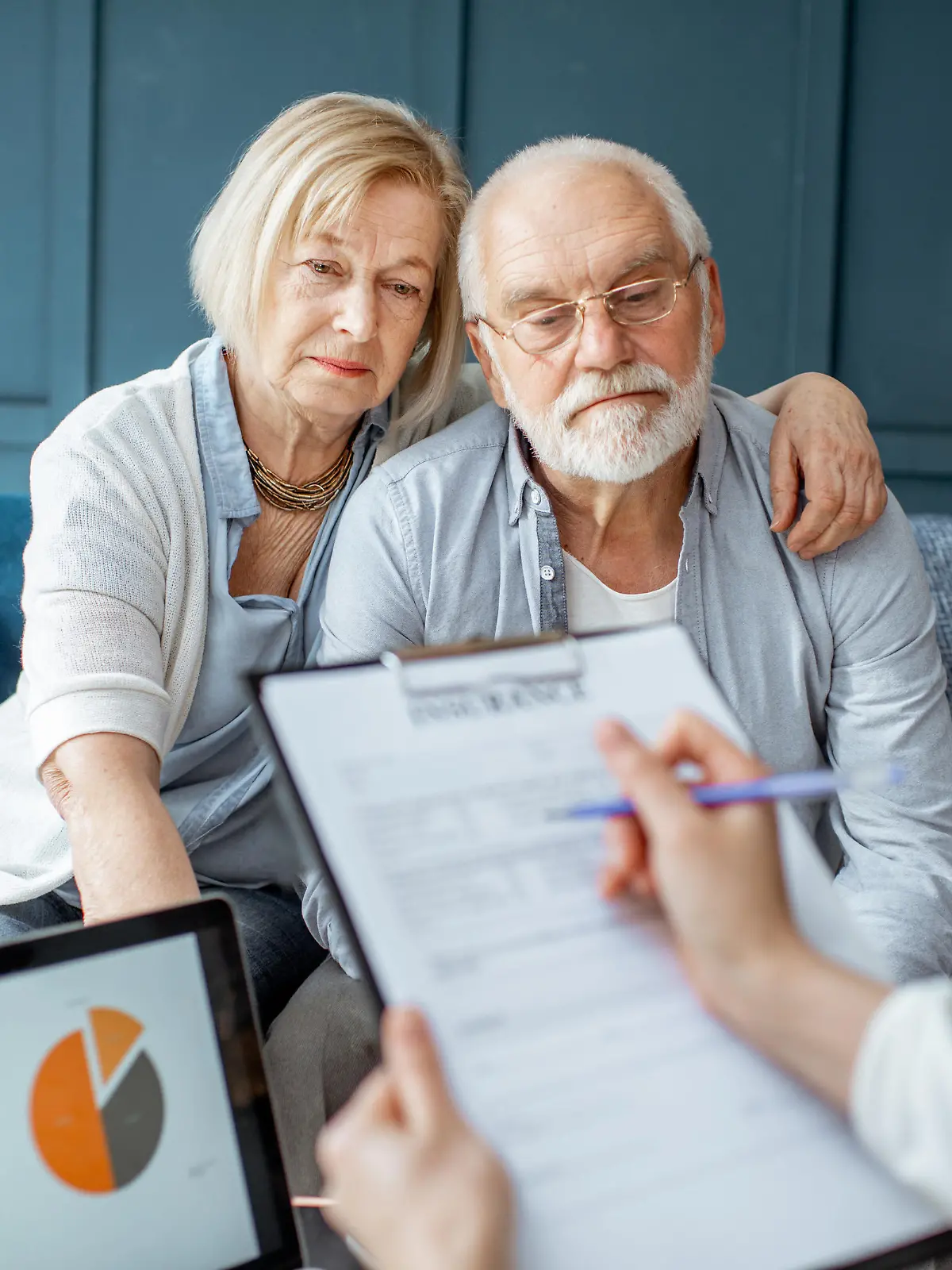 Senior couple with sad emotions during the meeting with financial consultant, signing some agreement in the office