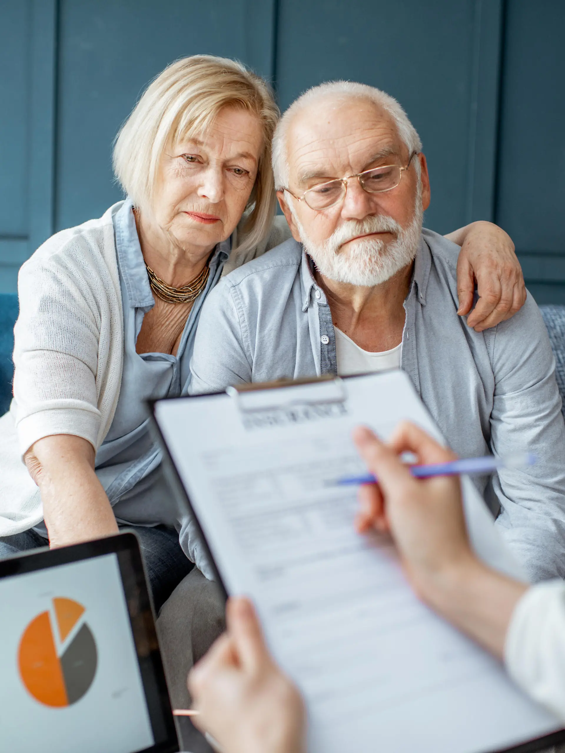 Senior couple with sad emotions during the meeting with financial consultant, signing some agreement in the office