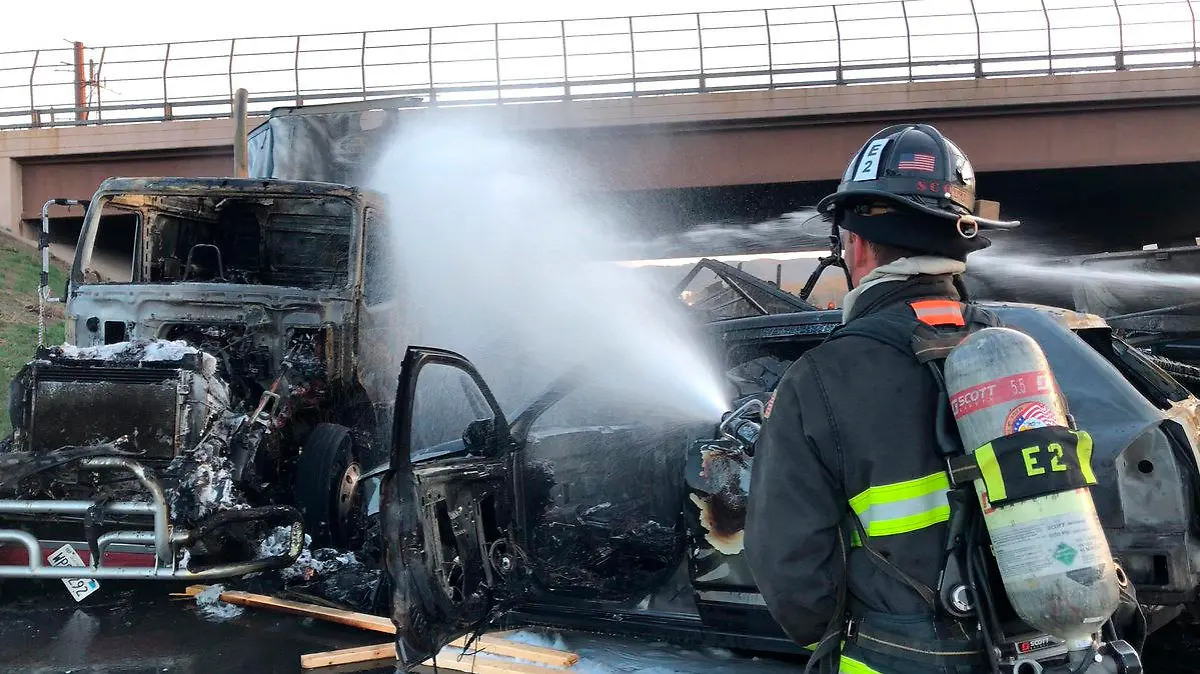 FILE - This Thursday, April 25, 2019 file photo provided by West Metro Fire Rescue shows a firefighter working the scene of a deadly pileup involving over two dozen vehicles near Denver. Colorado prosecutors, on Monday, May 20, want a judge to require a GPS monitor for Rogel Lazaro Aguilera-Mederos , the truck driver accused of causing the fiery pileup. (Ronda Scholting/West Metro Fire Rescue via AP,File)