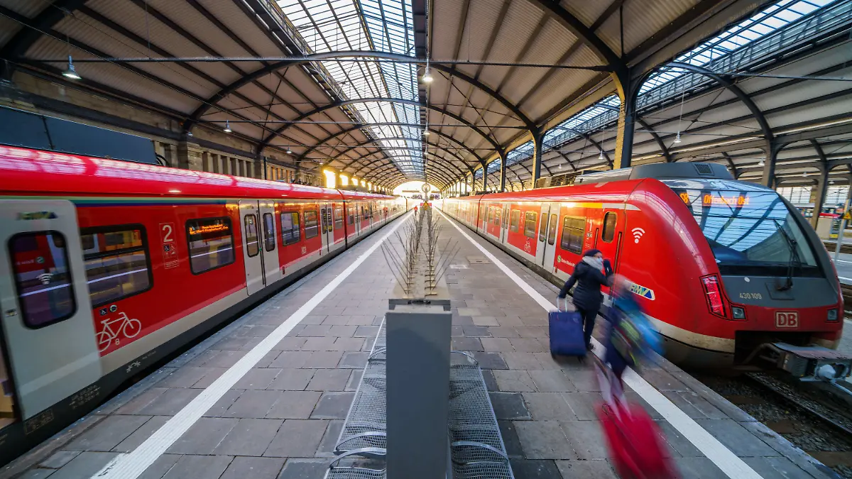 22.12.2021, Hessen, Wiesbaden: Bahnreisende gehen zu ihren Zügen. Seit den frühen Morgenstunden fahren S-Bahnen, Regionalzüge von Bahn, Vias und der HLB wieder fahrplanmäßig über die Haupttrasse in die Landeshauptstadt. Seit Mitte Juni 2021 war der Bahnhof nahezu stillgelegt. Die Fahrbahn der maroden Salzbachtalbrücke war absackt, Betonteile fielen auf die darunterliegende Bahnstrecke und der Zugverkehr musste auf diesem Abschnitt eingestellt werden. Foto: Andreas Arnold/dpa +++ dpa-Bildfunk +++