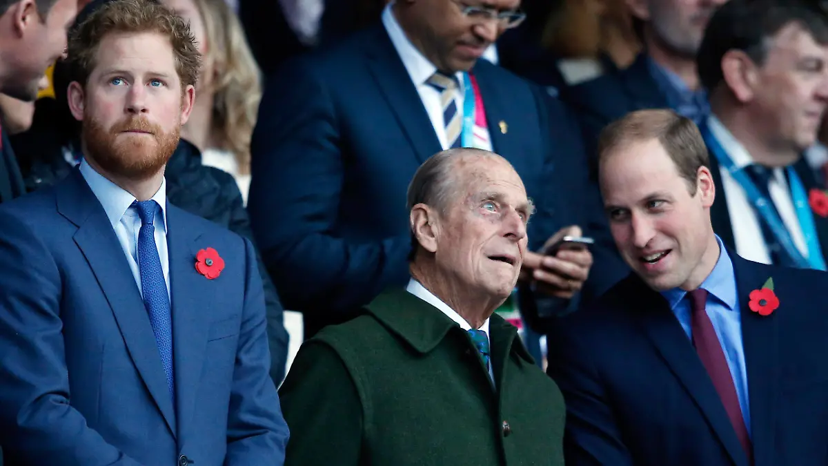 ARCHIV - 31.10.2015, Großbritannien, London: Prinz Harry (l) und sein Bruder Prinz William (r) stehen mit ihrem Großvater Prinz Philip, Herzog von Edinburgh, vor Beginn des Rugby World Cup Finales zwischen Neuseeland und Australien im Twickenham Stadion. Anlässlich der Beisetzung von Prinz Philip kommt es nun wohl zum Wiedersehen von Harry mit der royalen Familie. Gelingt eine Aussöhnung - vor allem mit Bruder William? (zu dpa «Medien: Prinz Harry in Großbritannien eingetroffen») Foto: Alastair Grant/AP/dpa +++ dpa-Bildfunk +++