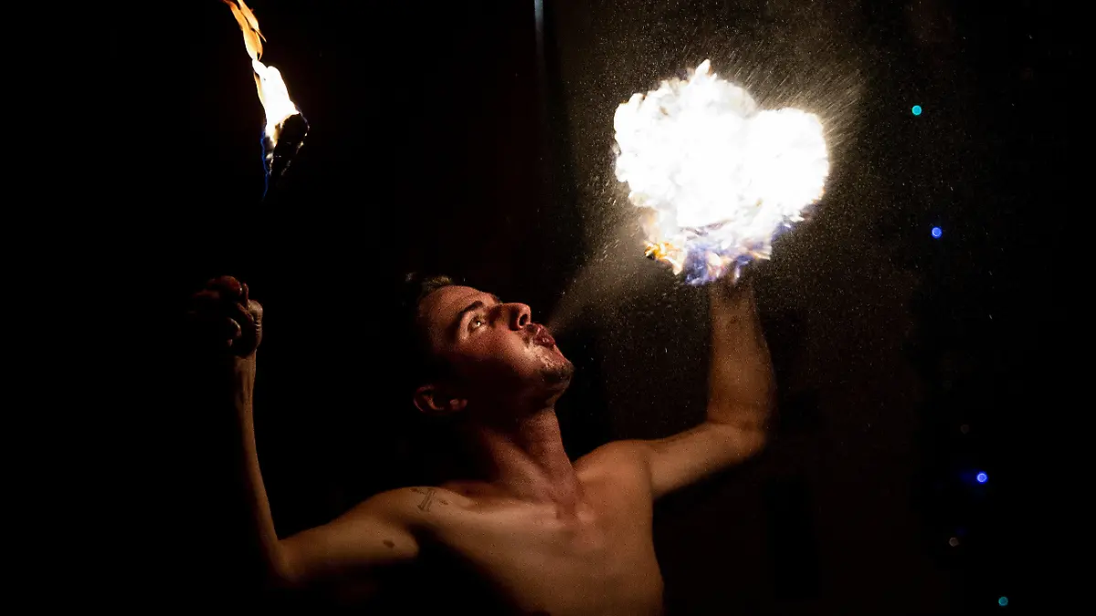 20.12.2021, Hessen, Frankfurt/Main: ·Ali Bengali·, alias Adriano Buegler, tritt im ·Familienzirkus Delmonde· als Feuerspucker auf. Nachdem der Zirkus aufgrund der Corona-Pandemie in den vergangen zwei Jahren kaum Vorstellungen anbieten konnte, kann die Betreiberfamilie auch im zweiten Corona-Winter kaum die laufenden Kosten decken. Aufzugeben ist für die aus zwölf Mitgliedern bestehende Zirkustruppe nach mehr als sieben Generationen im Nomadenleben dennoch keine Option. Foto: Boris Roessler/dpa +++ dpa-Bildfunk +++