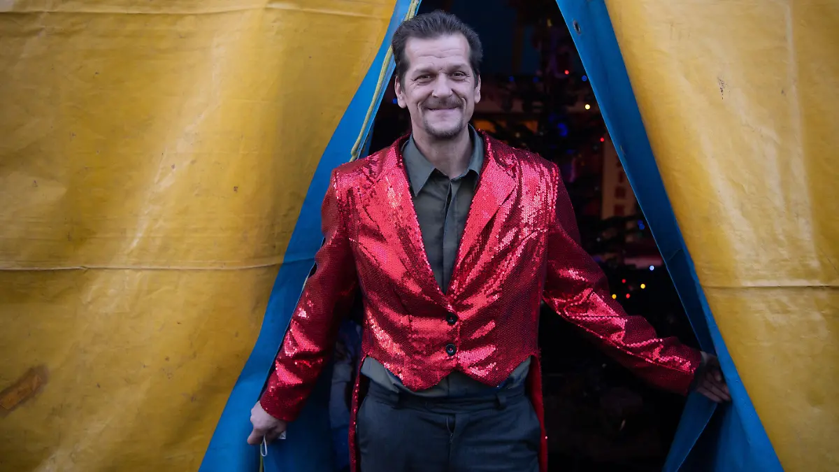 20.12.2021, Hessen, Frankfurt/Main: Zirkusdirektor Tino Krämer wartet im ·Familienzirkus Delmonde· auf den Beginn der Vorstellung. Nachdem der Zirkus aufgrund der Corona-Pandemie in den vergangen zwei Jahren kaum Vorstellungen anbieten konnte, kann die Betreiberfamilie auch im zweiten Corona-Winter kaum die laufenden Kosten decken. Aufzugeben ist für die aus zwölf Mitgliedern bestehende Zirkustruppe dennoch keine Option. Foto: Boris Roessler/dpa +++ dpa-Bildfunk +++
