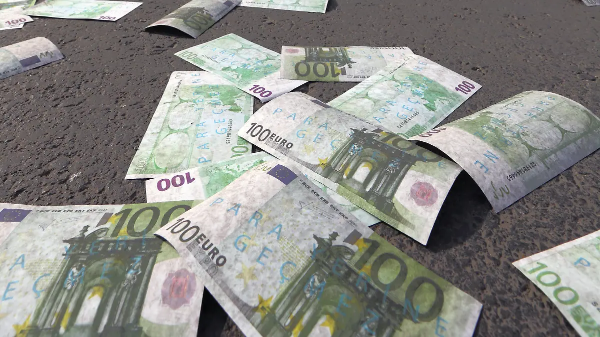 Cars wait for green light on a main road covered with banknotes after members of the main opposition Republican People's Pary, CHP, has thrown fake Euro bills into the air during an anti-government protest denouncing a corruption scandal that has shaken Prime Minister Recep Tayyip Erdogan¿s government, in Ankara, Turkey, Saturday, March 1, 2014. Protesters shouted ¿there¿s a thief! ¿ as they distributed an amount of 30 million fake bills, a day after five remaining suspects jailed in a vast corruption investigation that has shaken Erdogan¿s government, including two former ministers¿ sons and a businessman suspected of bribery and illicit money transfers to Iran, have been released on parole pending trial.(AP Photo/Burhan Ozbilici)
