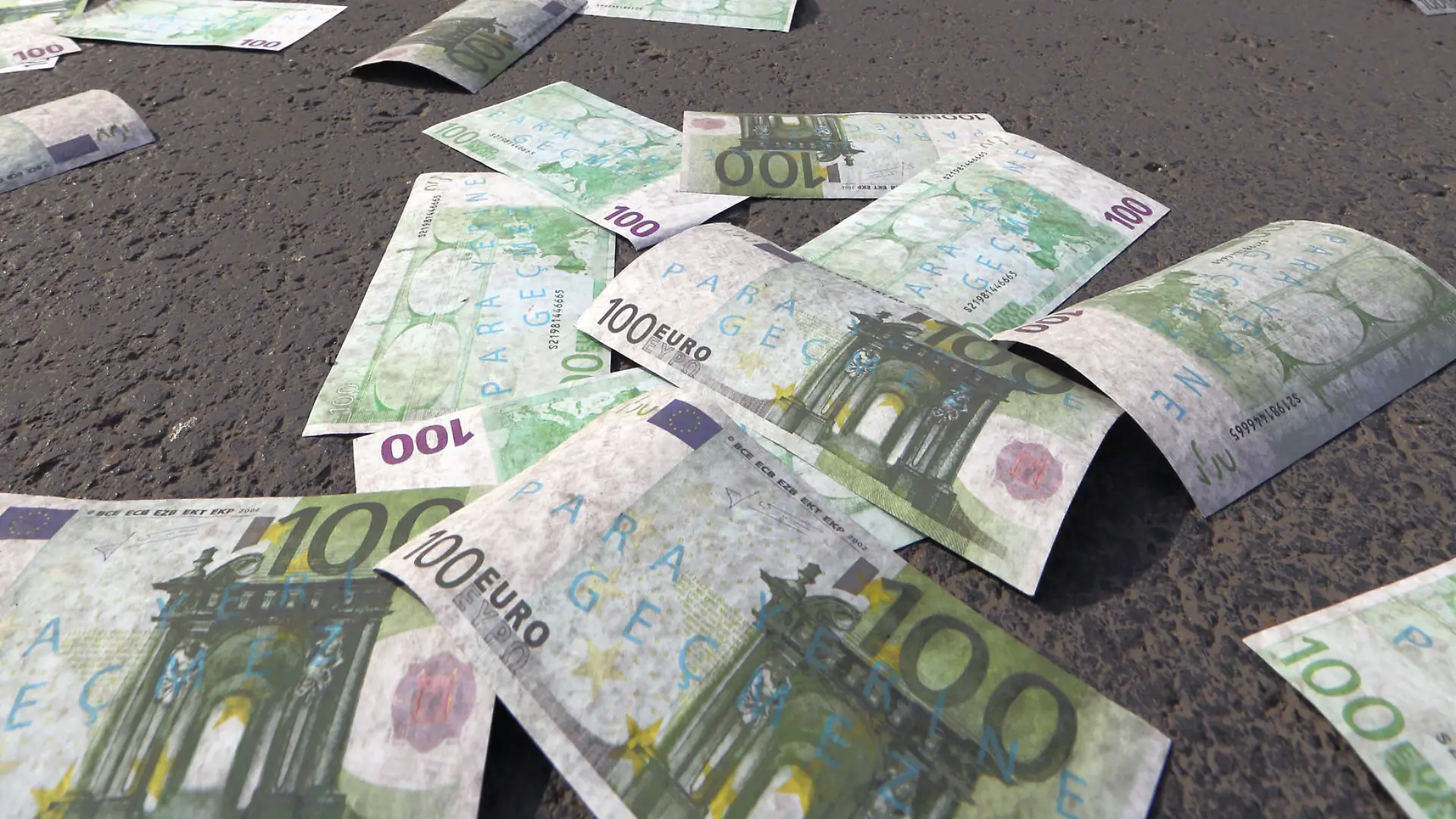 Cars wait for green light on a main road covered with banknotes after members of the main opposition Republican People's Pary, CHP, has thrown fake Euro bills into the air during an anti-government protest denouncing a corruption scandal that has shaken Prime Minister Recep Tayyip Erdogan¿s government, in Ankara, Turkey, Saturday, March 1, 2014. Protesters shouted ¿there¿s a thief! ¿ as they distributed an amount of 30 million fake bills, a day after five remaining suspects jailed in a vast corruption investigation that has shaken Erdogan¿s government, including two former ministers¿ sons and a businessman suspected of bribery and illicit money transfers to Iran, have been released on parole pending trial.(AP Photo/Burhan Ozbilici)