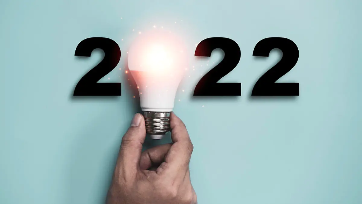 Hand holding Light bulb with 2022 year for happy new year idea and creative thinking concept.