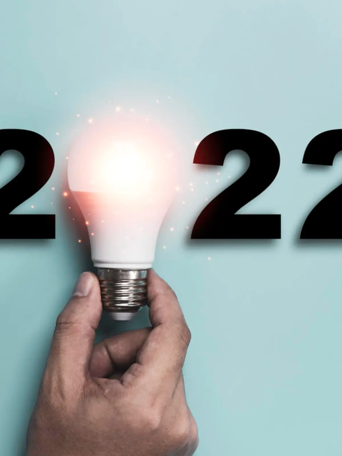 Hand holding Light bulb with 2022 year for happy new year idea and creative thinking concept.