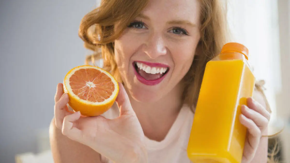 Portrait of woman holding orange and orange juice, Bildnis der Frau, die orange und Orangensaft haelt Keine Weitergabe an Drittverwerter.