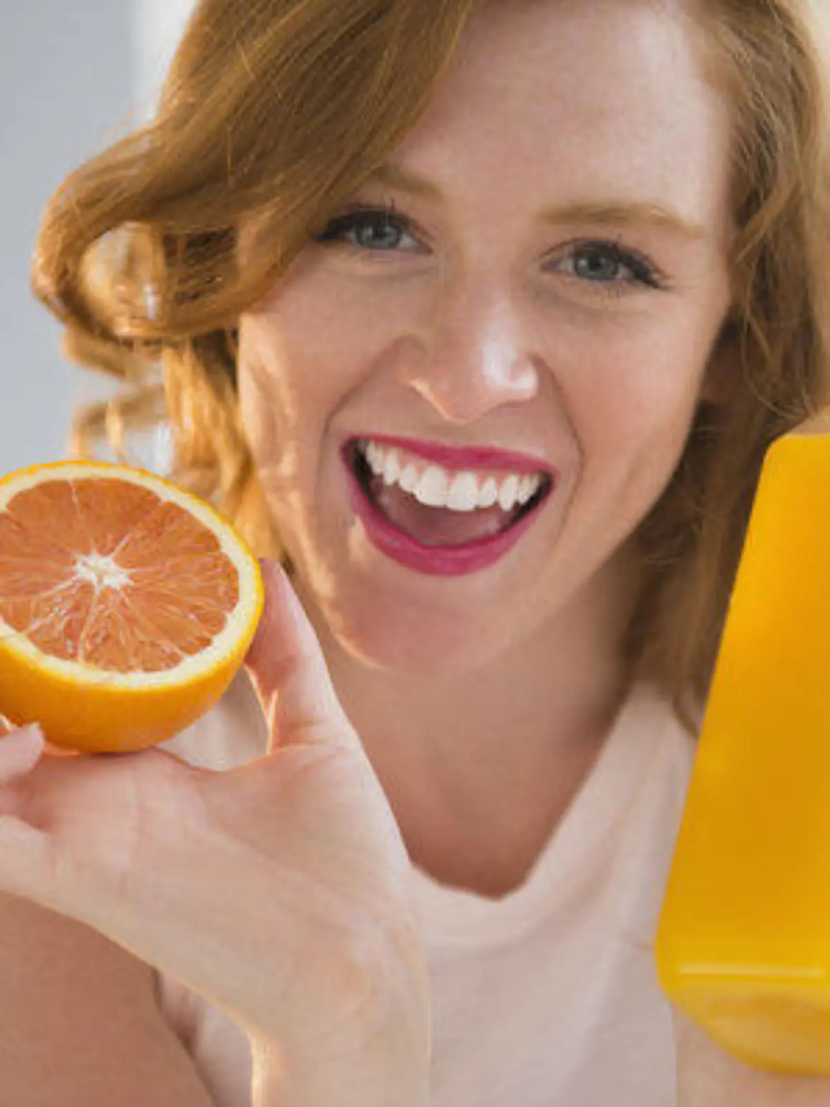 Portrait of woman holding orange and orange juice, Bildnis der Frau, die orange und Orangensaft haelt Keine Weitergabe an Drittverwerter.