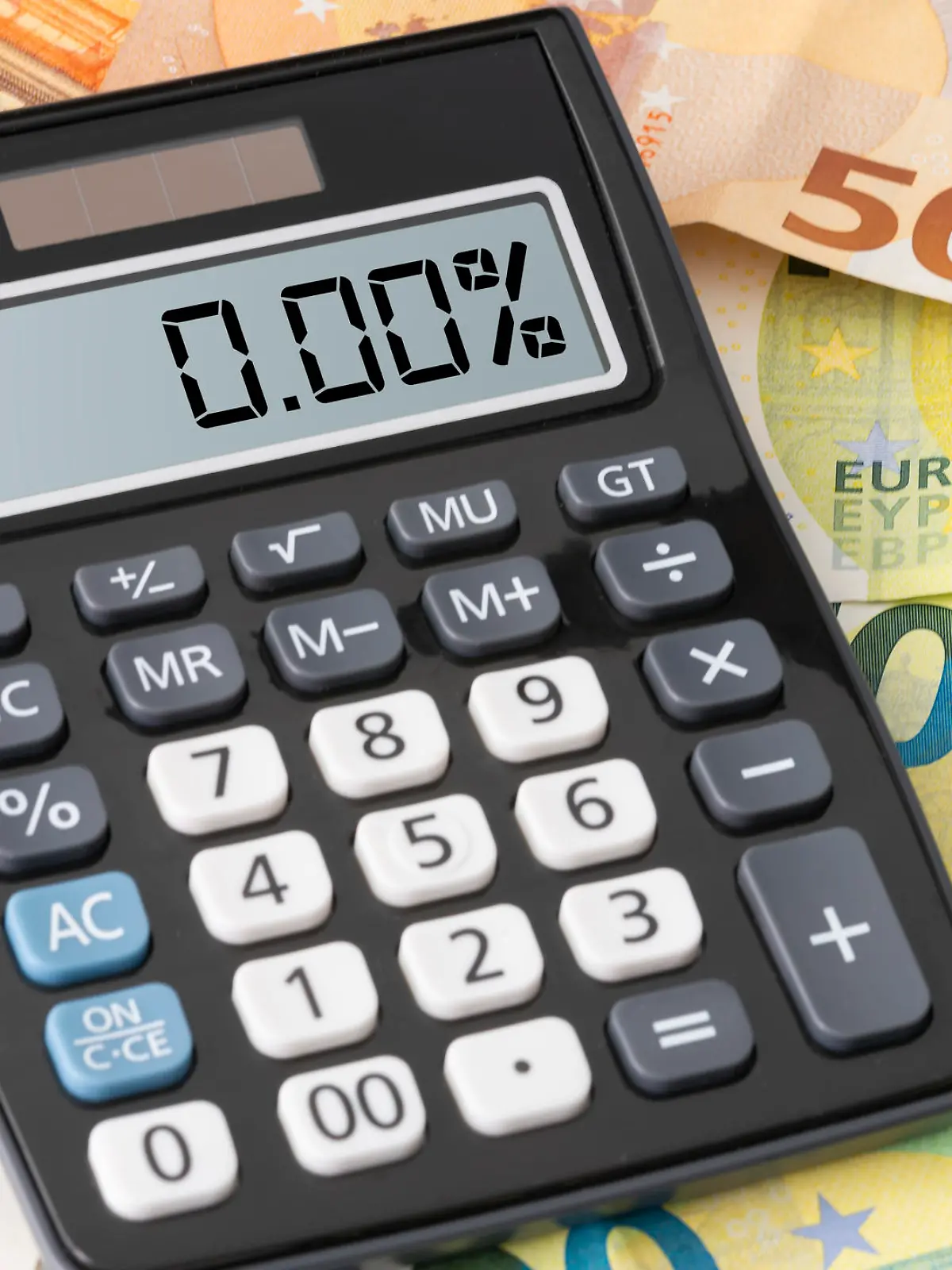 calculator showing zero percent interest rate on Euro banknotes, cheap borrowing concept