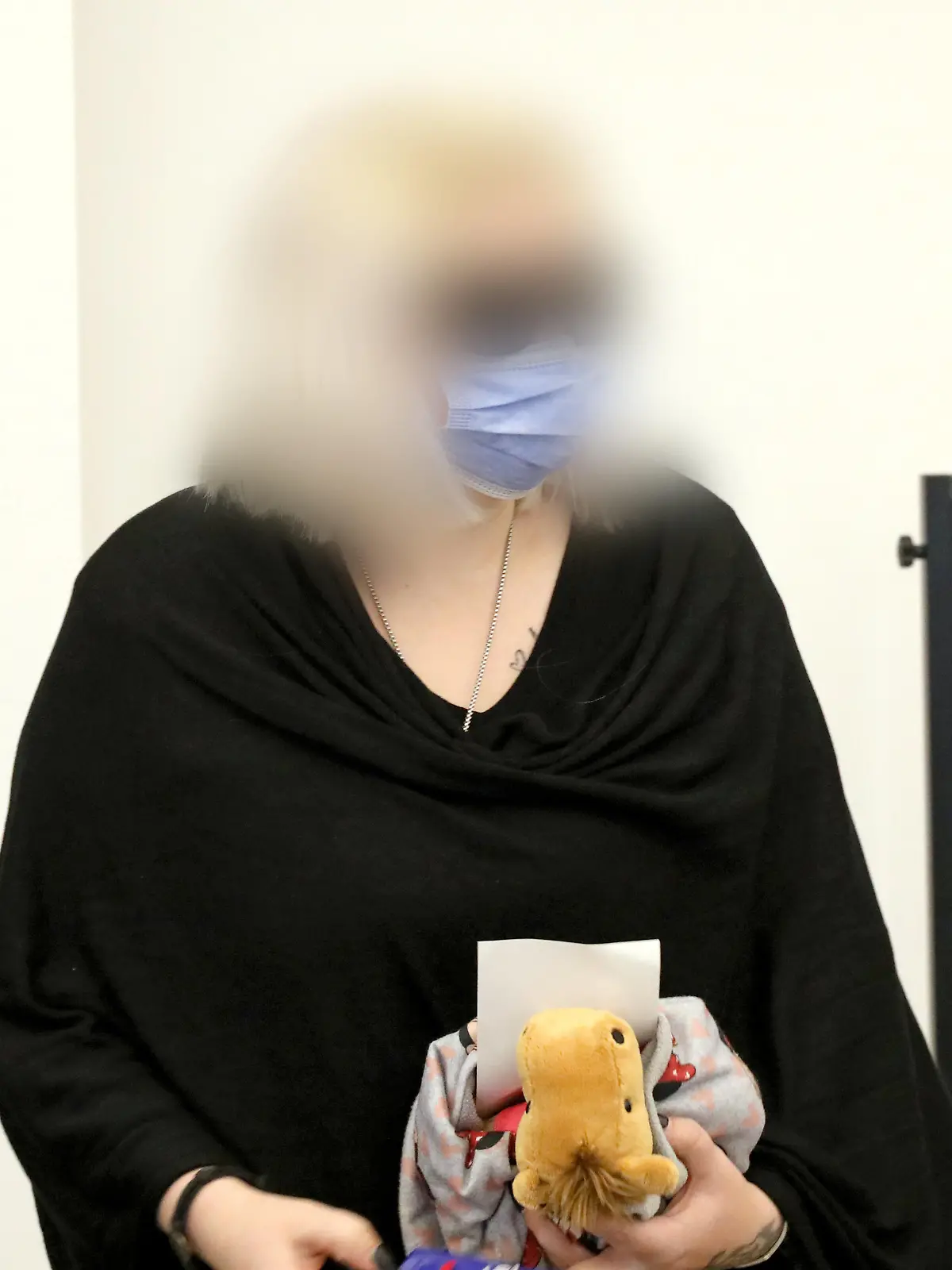 21.12.2021, Mecklenburg-Vorpommern, Neubrandenburg: Die angeklagte Mutter kommt zur Fortsetzung des Prozesses um den gewaltsamen Tod der sechsjährigen Leonie aus Torgelow mit einem Stofftier in den Saal des Amtsgerichts. Der Angeklagten wird fahrlässige Tötung durch Unterlassen vorgeworfen. Das Urteil gegen die 27-jährige soll am Nachmittag verkündet werden. Foto: Bernd Wüstneck/dpa-Zentralbild/dpa - ACHTUNG: Person(en) wurde(n) aus rechtlichen Gründen gepixelt +++ dpa-Bildfunk +++