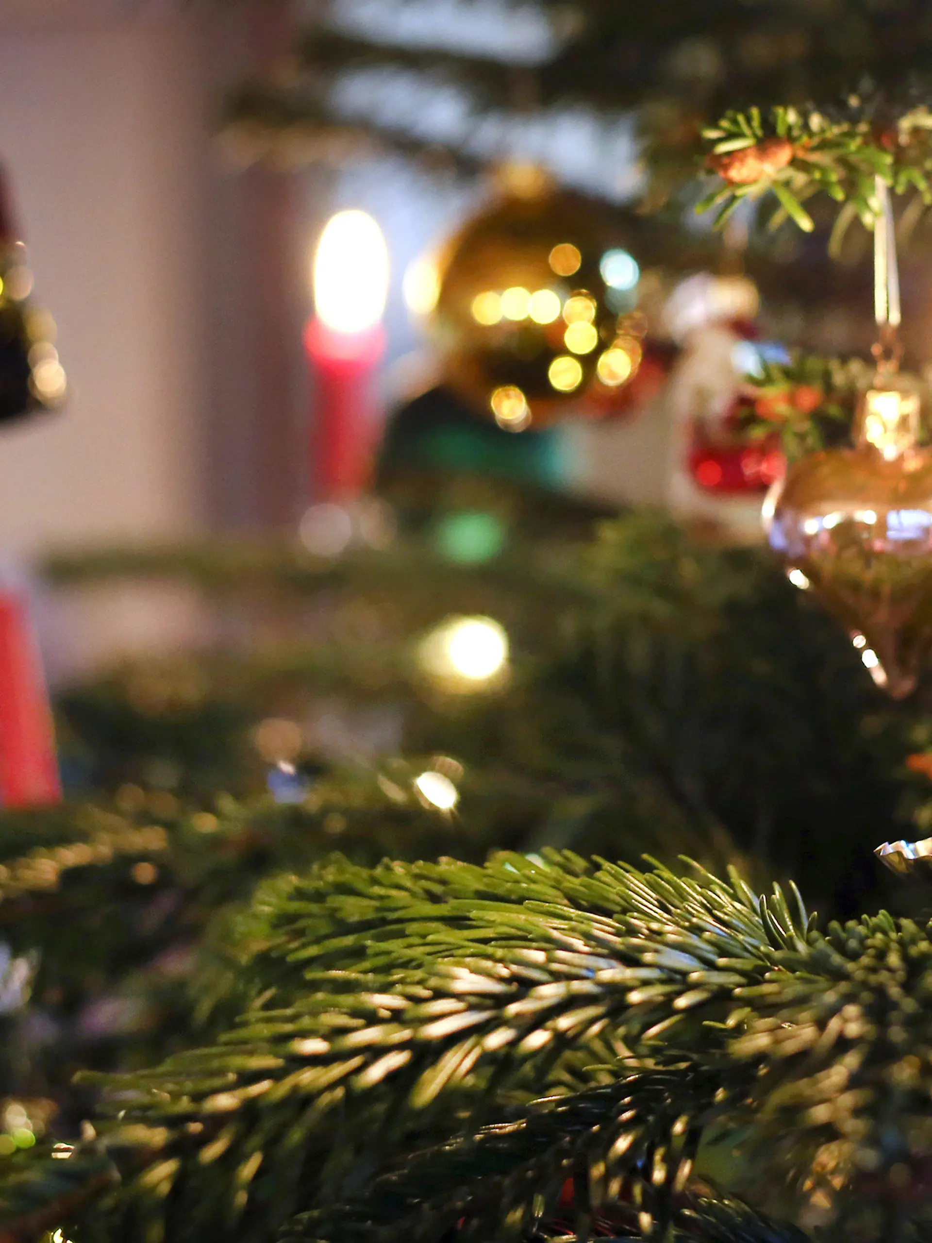 ARCHIV - 25.12.2019, Bayern, Kaufbeuren: Kerzen brennen an einem festlich geschmückten Weihnachtsbaum. Bundeskanzler Scholz (SPD) und die Ministerpräsidentinnen und -präsidenten der Länder beraten über erneute Maßnahmenverschärfungen, um der  befürchteten Omikron-Welle in der Corona-Pandemie begegnen. Die Regeln für Weihnachten bleiben voraussichtlich wie sie sind. Foto: Karl-Josef Hildenbrand/dpa +++ dpa-Bildfunk +++
