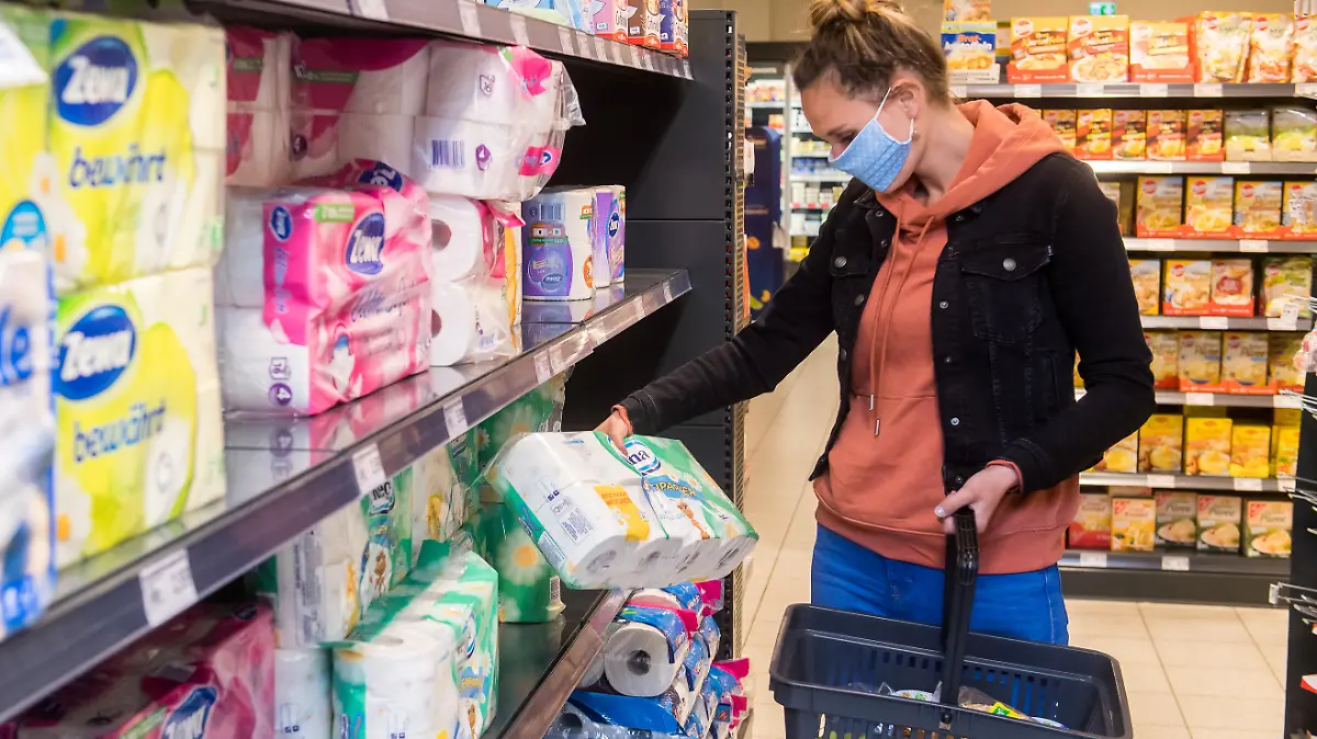 ILLUSTRATION - Eine Frau mit Mundschutz-Maske kauft am 29.04.2020 in Flensburg in einem Supermarkt ein (gestellte Szene). Foto: Benjamin Nolte || Modellfreigabe vorhanden