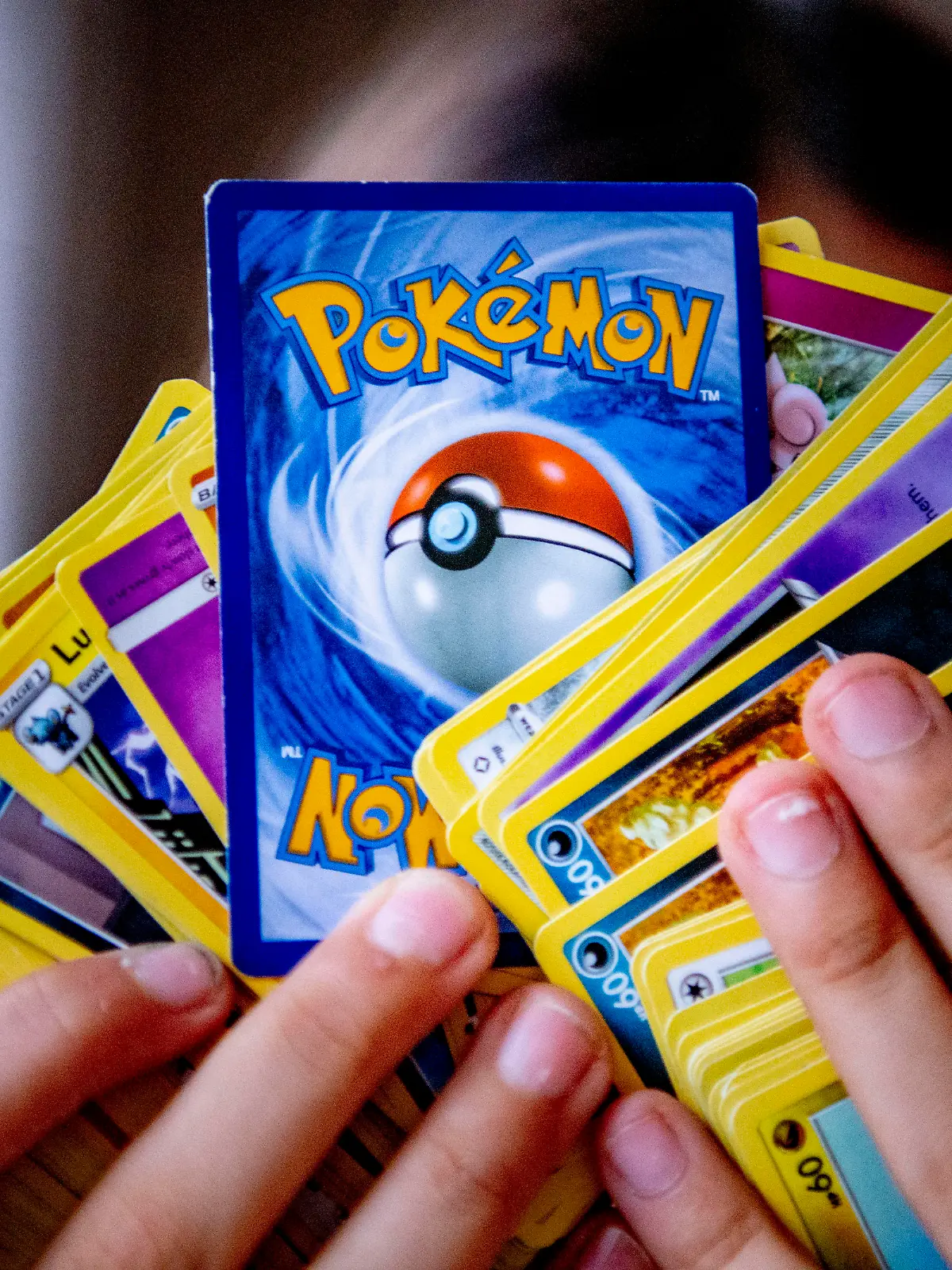 ROTTERDAM - A girl with her pokemon card collection. Pokémon cards are gold and very popular and sold out everywhere. In addition, Pokémon is 25 years old this year and special editions of the cards are now coming out. A pack of 10 cards normally costs around seven euros. Robin Utrecht