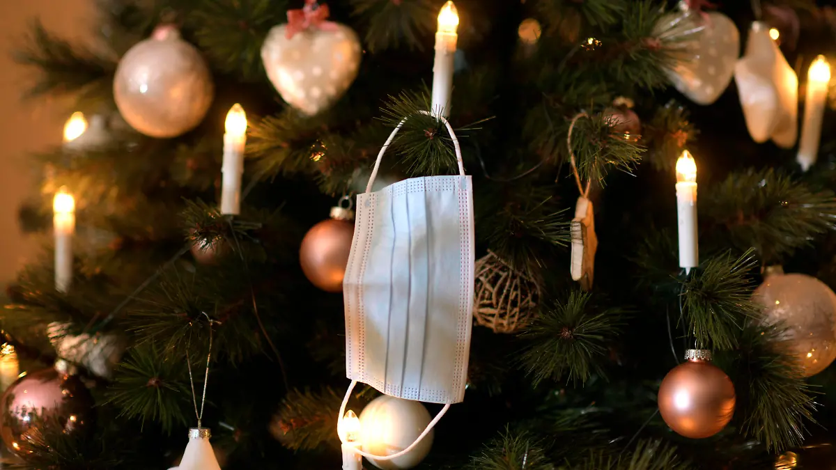 23.11.2020, Symbolbild, Am Weihnachstbaum im Wohnzimmer hängt ein Mund-Nasen-Schutz, Wegen der Corona-Pandemie könnte Weihnachten dieses Jahr etwas einsamer werden. 23.11.2020, Weihnachten in Einsamkeit wegen Corona 23.11.2020, Weihnachten in Einsamkeit wegen Corona *** 23 11 2020, Symbolic picture, On the Christmas tree in the living room hangs a mouth nose protection, Because of the Corona pandemic Christmas could be a little bit lonelier this year 23 11 2020, Christmas in loneliness because of Corona 23 11 2020, Christmas in loneliness because of Corona